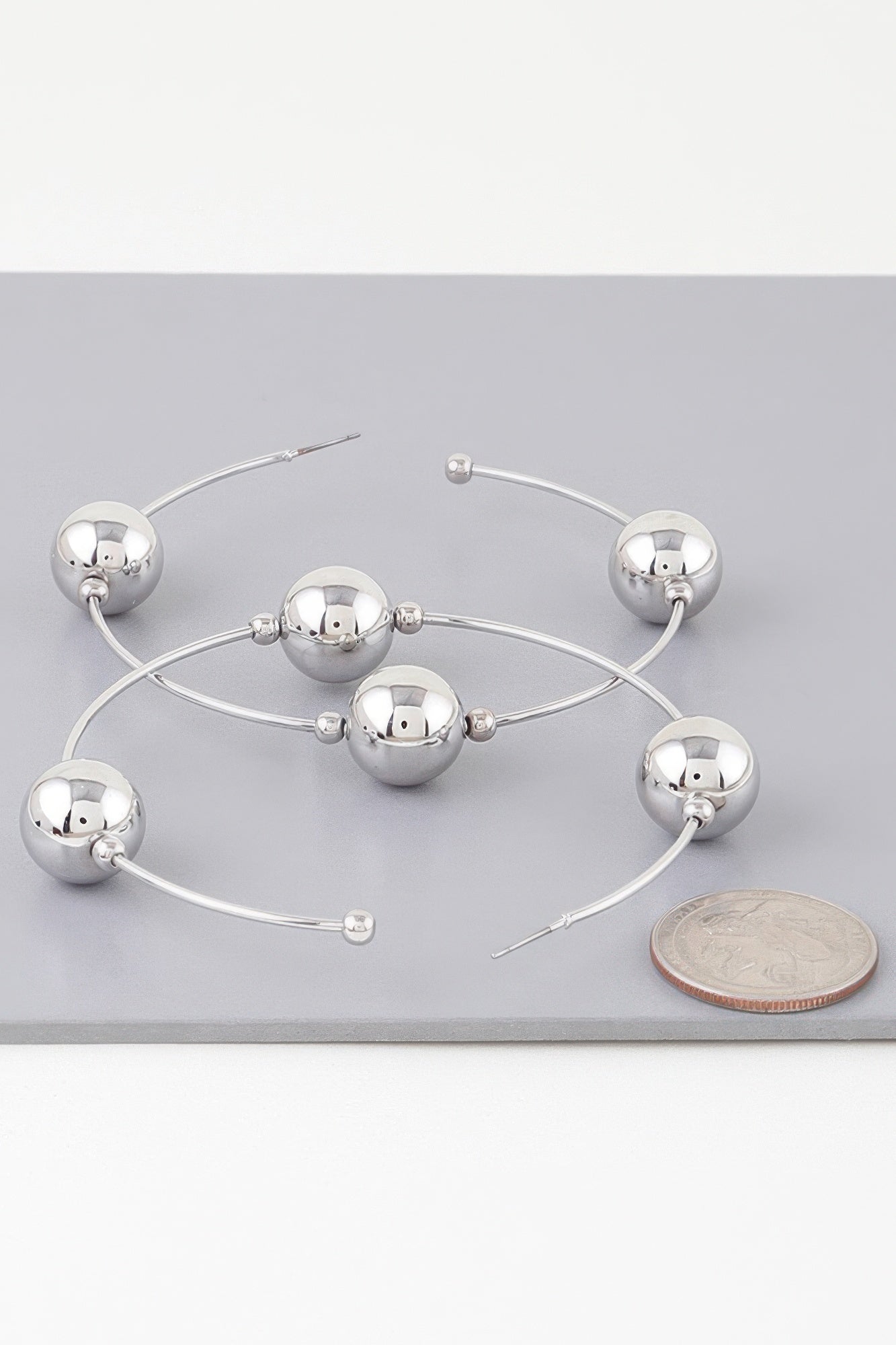 Triple shiny bead hoop earrings in silver-tone, three round beads on hoops
