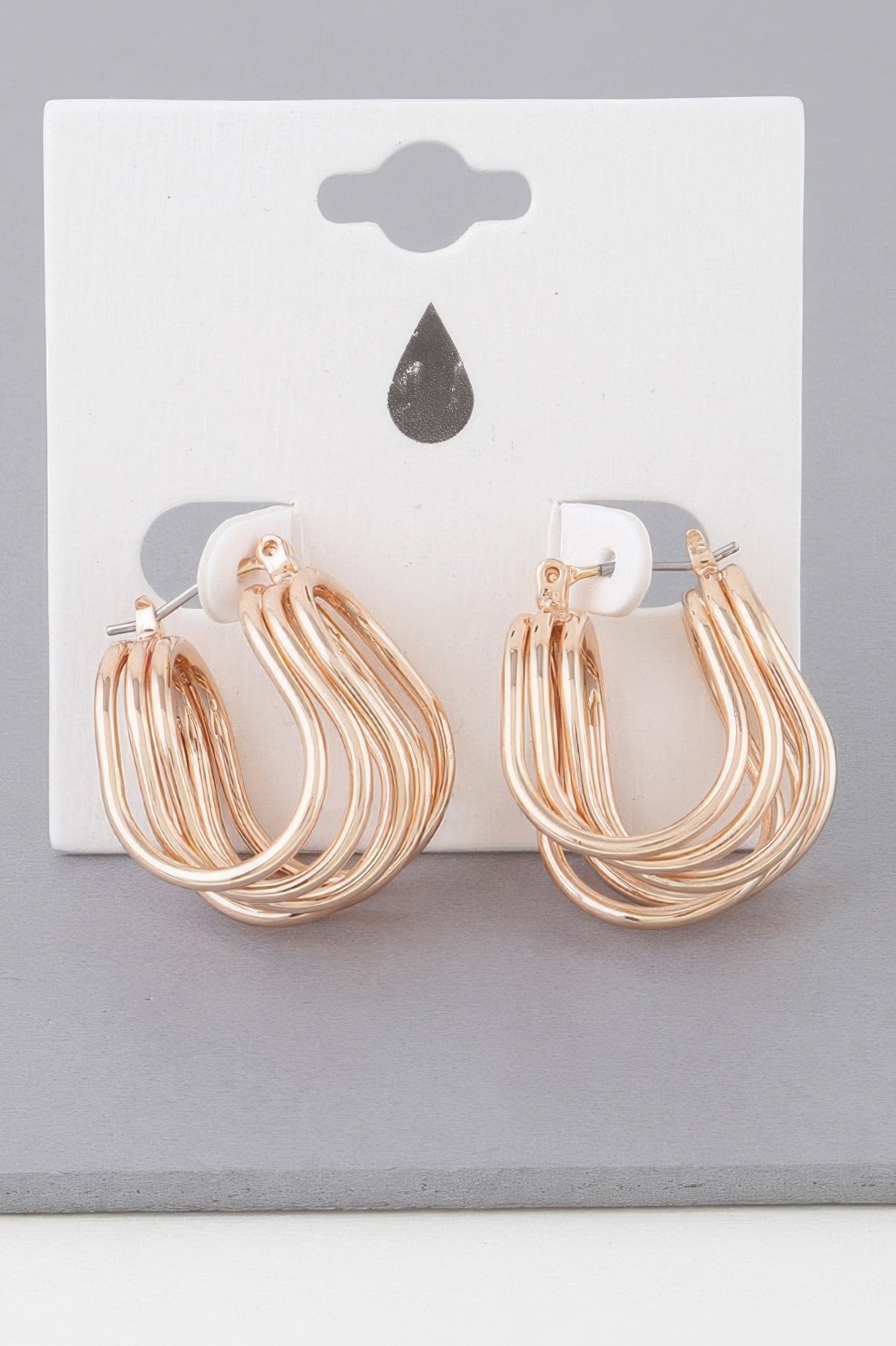Triple shiny wire hoop earrings, gold-toned wrap design, front view