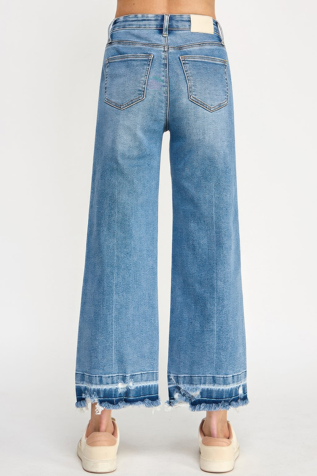 Back view: high-rise wide-leg jeans in blue wash with frayed released hem