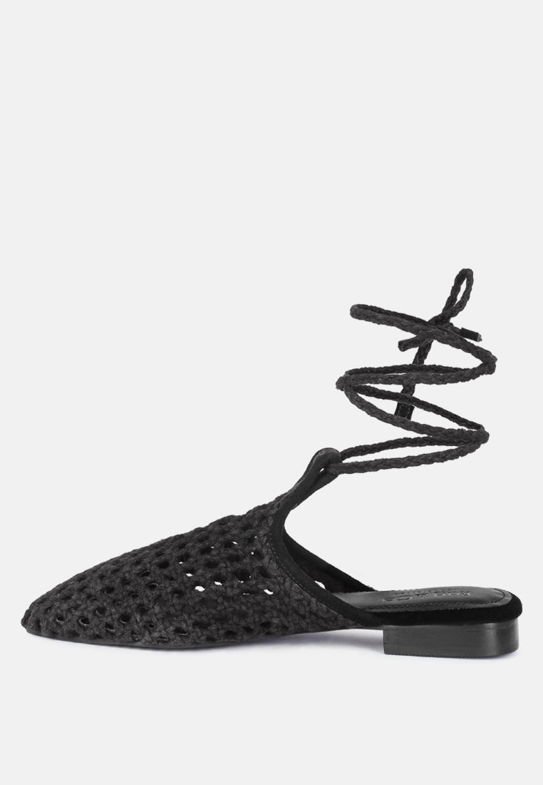 Black point-toe mule with woven honeycomb texture and ankle tie straps