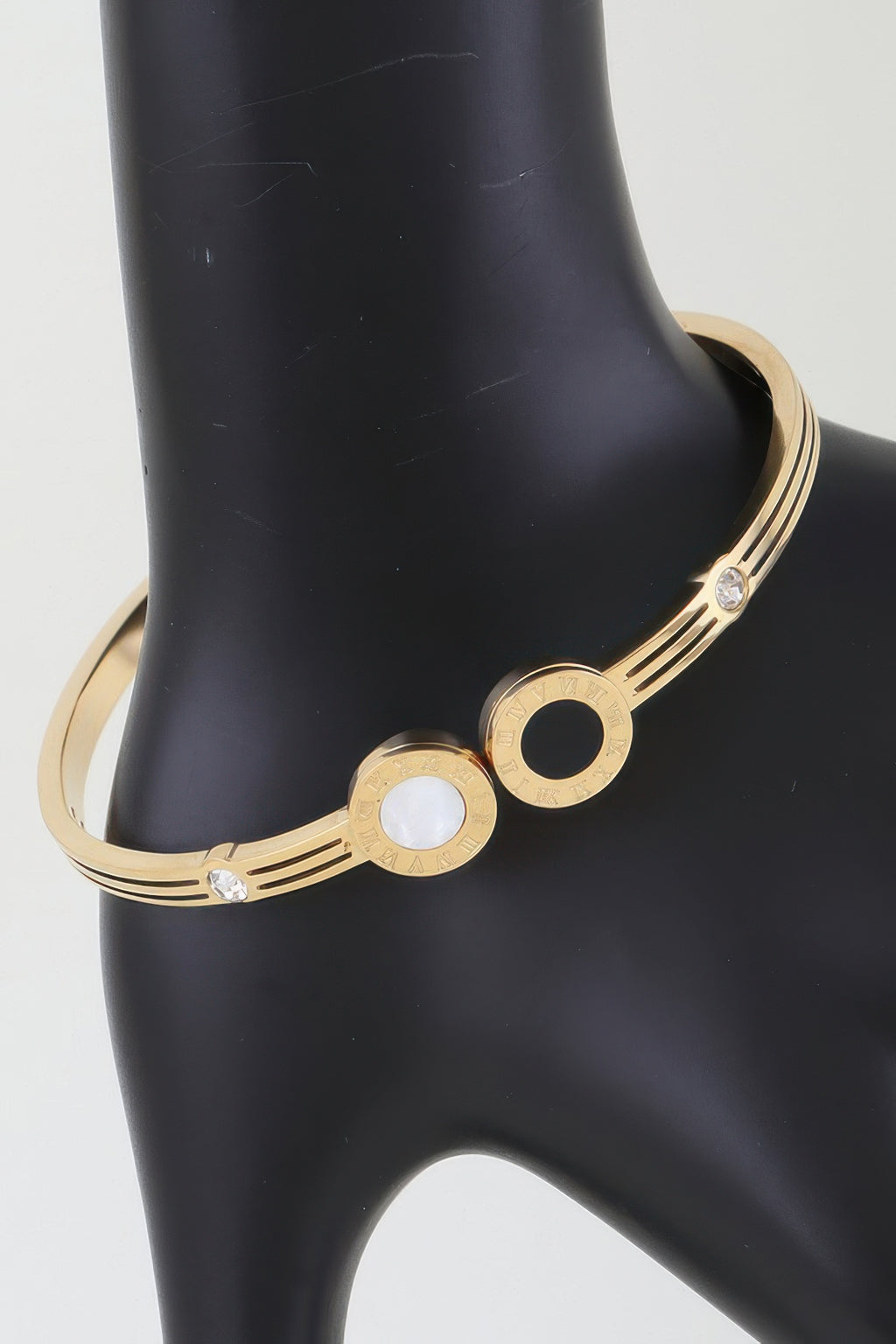 Gold-tone wrap bracelet with twin clock face charms and black/clear stones