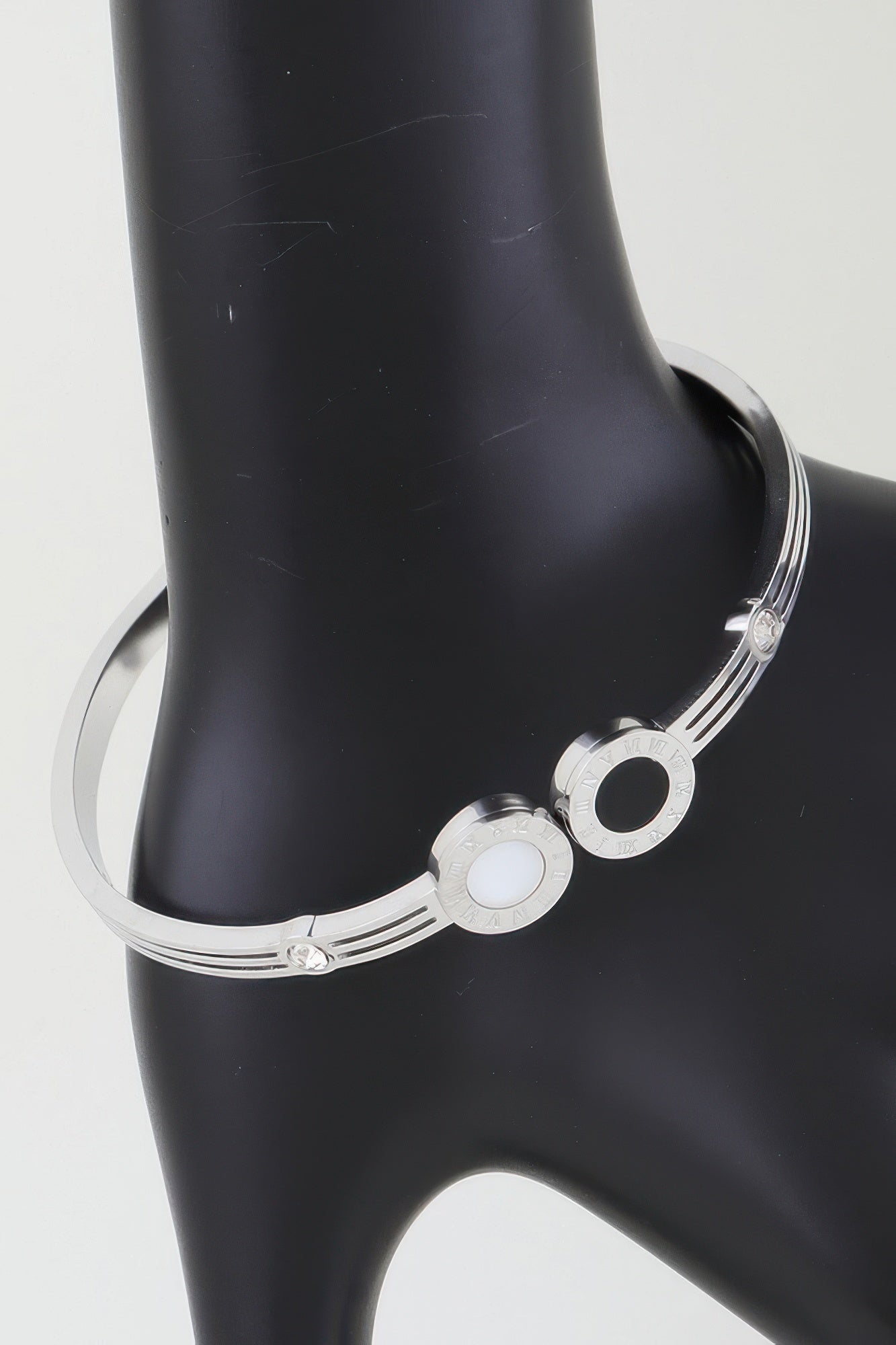 Silver-tone wrap bracelet with twin clock face charms, black and white centers