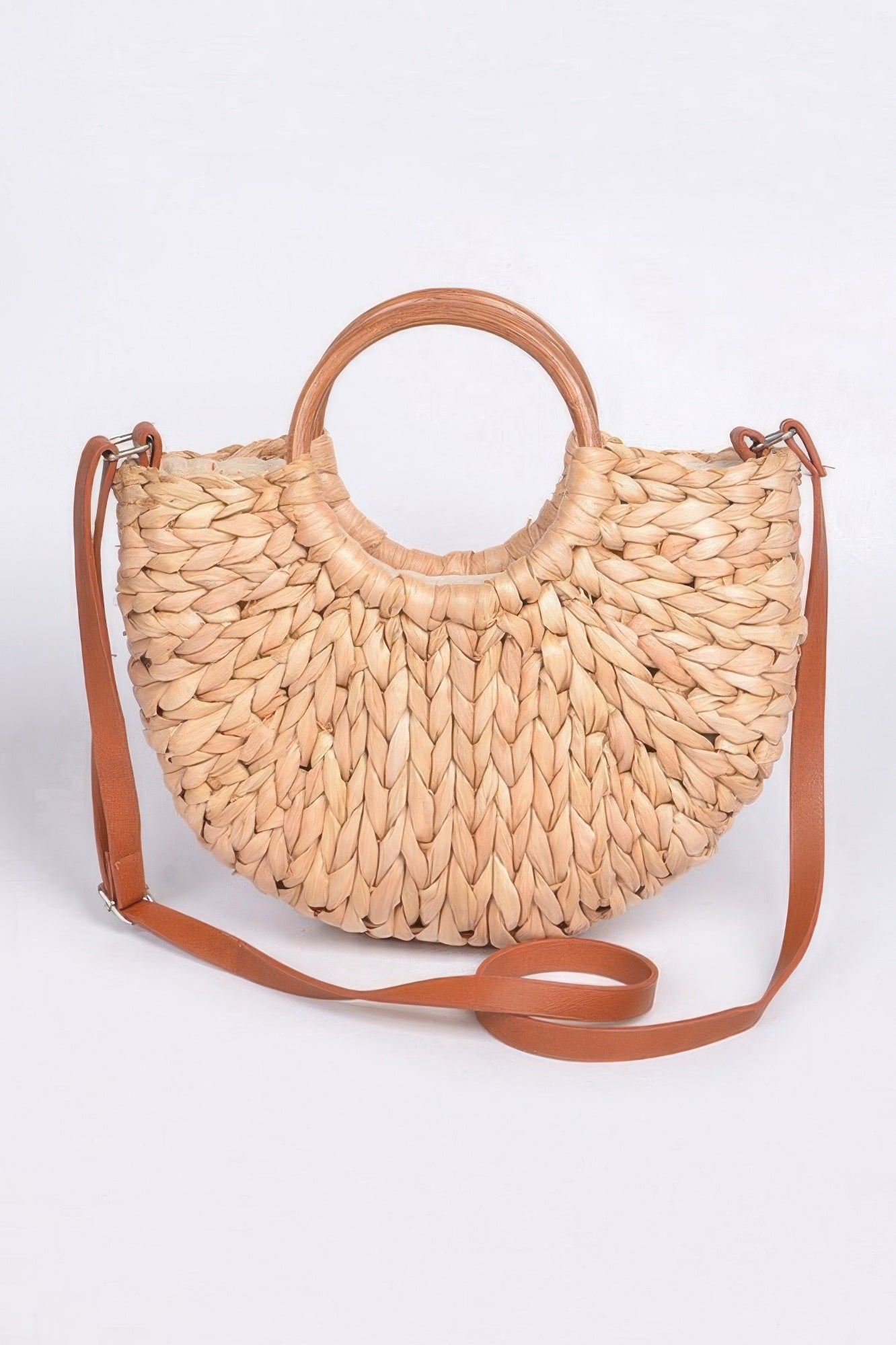 Natural woven clutch bag with twist-knotted handle and tan crossbody strap.