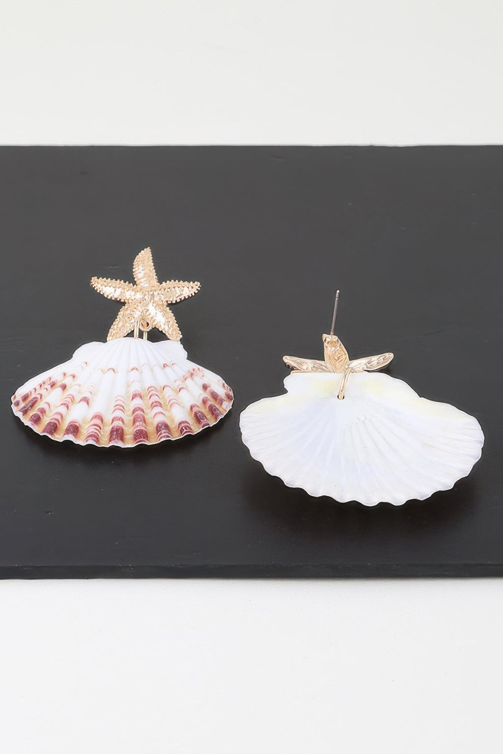Pair of gold-tone starfish shell earrings: white scallop drop with pink wave patterned base