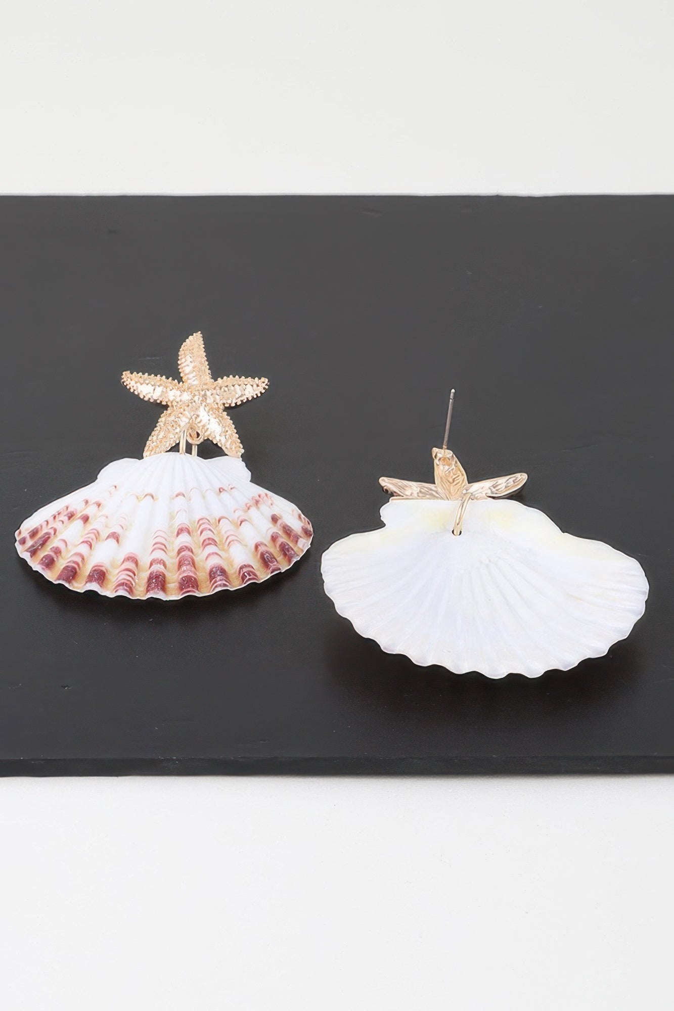 Pair of gold-tone starfish shell earrings: white scallop drop with pink wave patterned base