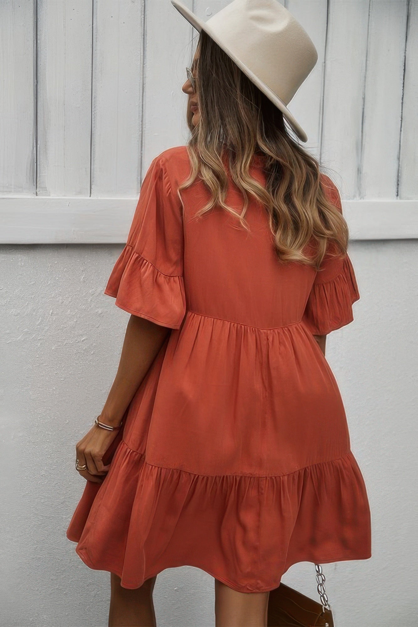 Orange backless? no—orange V-neck button dress with tiered ruffle hem and puff sleeves.