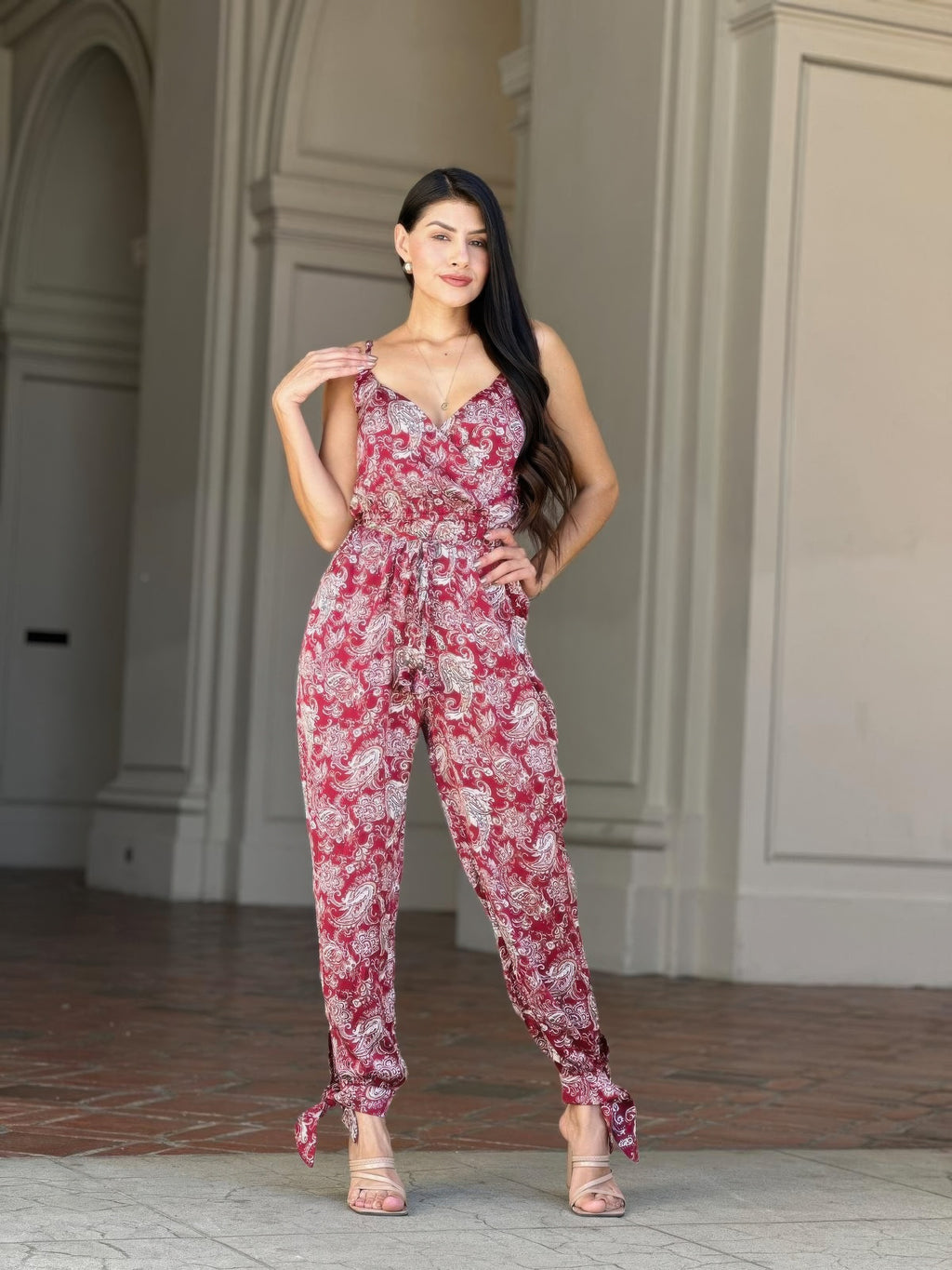V-neck sleeveless paisley jumpsuit with tie waist, red-and-white print