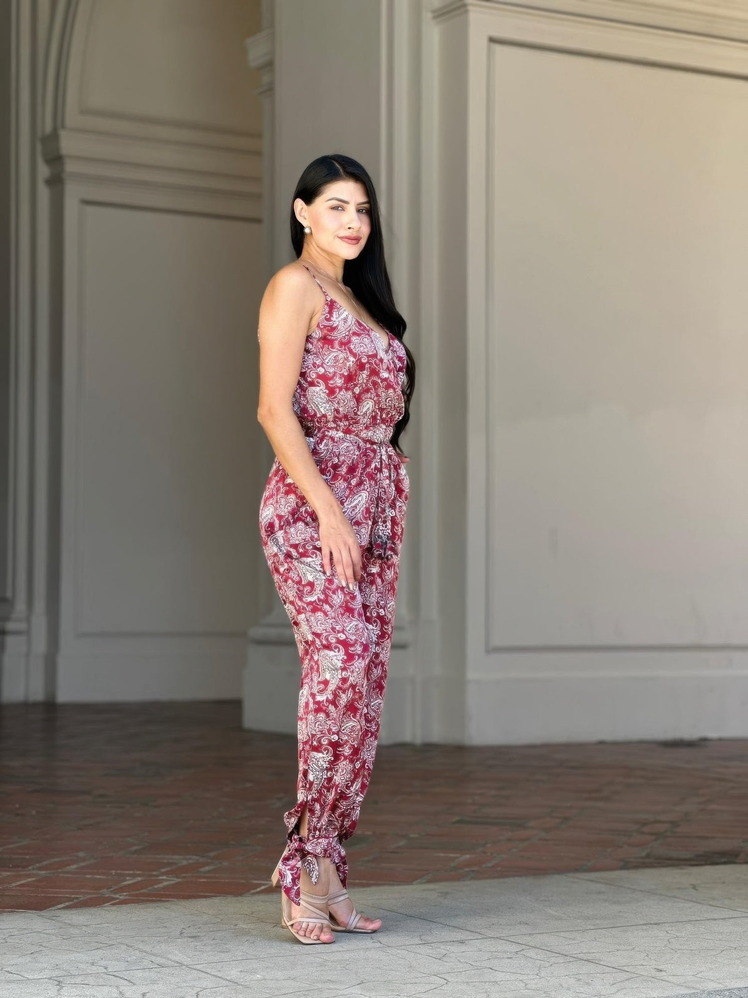 Full-length view: V-neck sleeveless paisley jumpsuit with tie waist