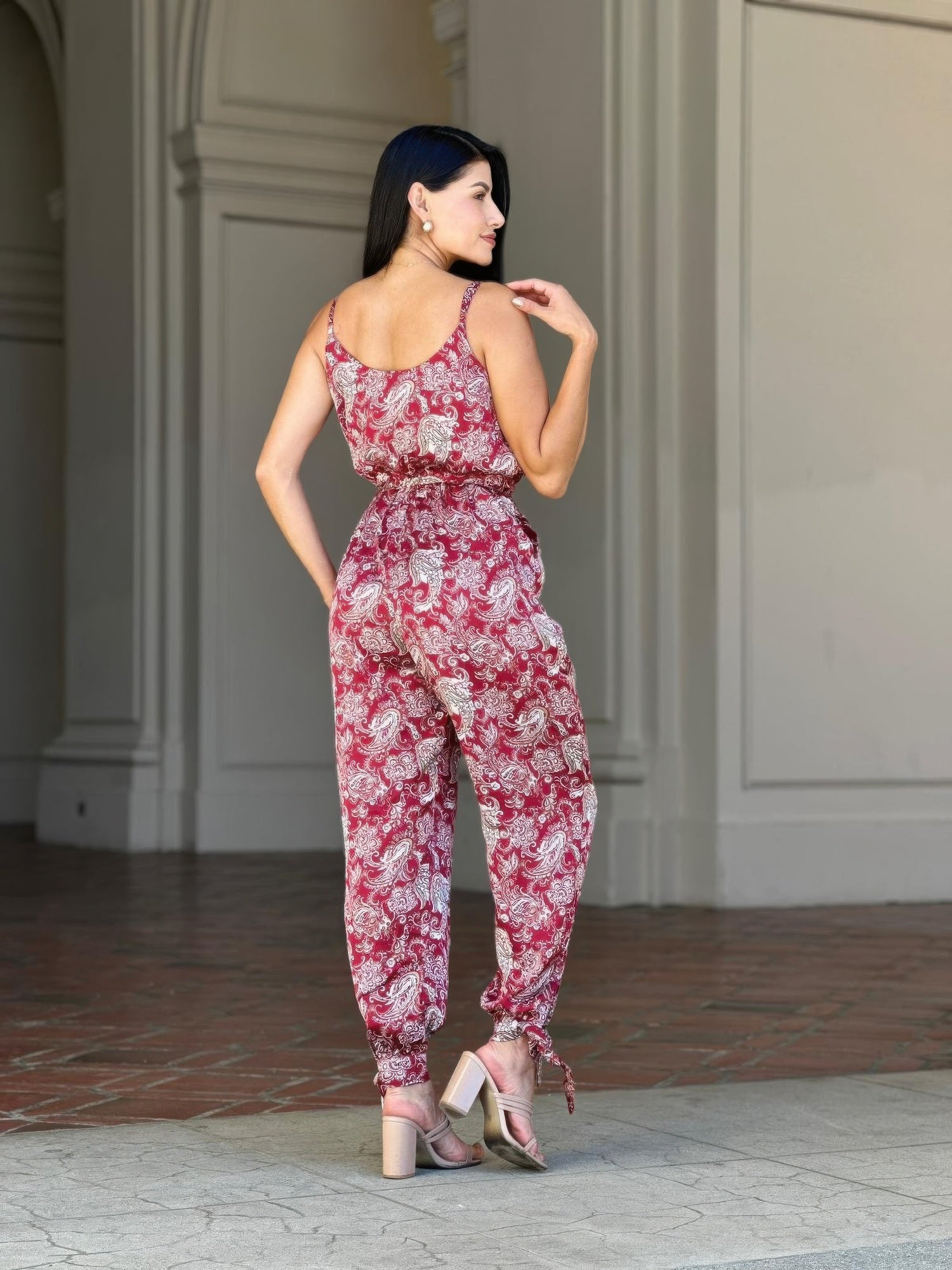 Back view: sleeveless paisley jumpsuit with tie-waist at the waist