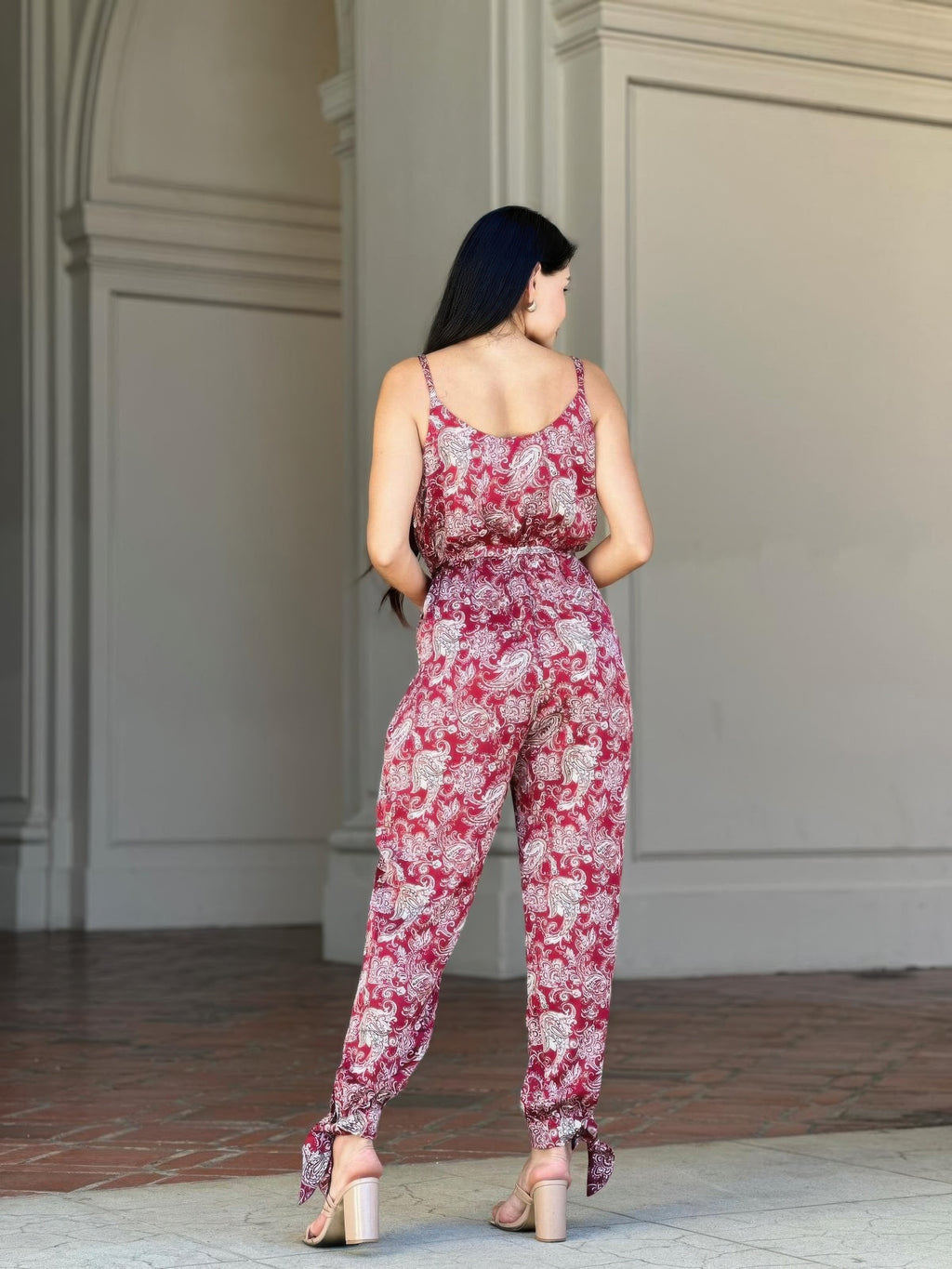 Rear three-quarter view: paisley sleeveless jumpsuit with tie waist