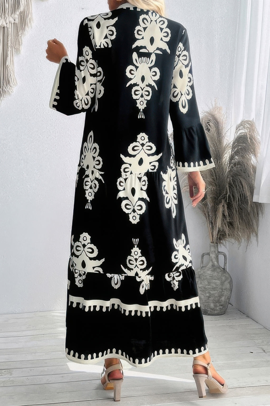 Black button-front maxi dress with V-neck and stand collar; bold white floral pattern