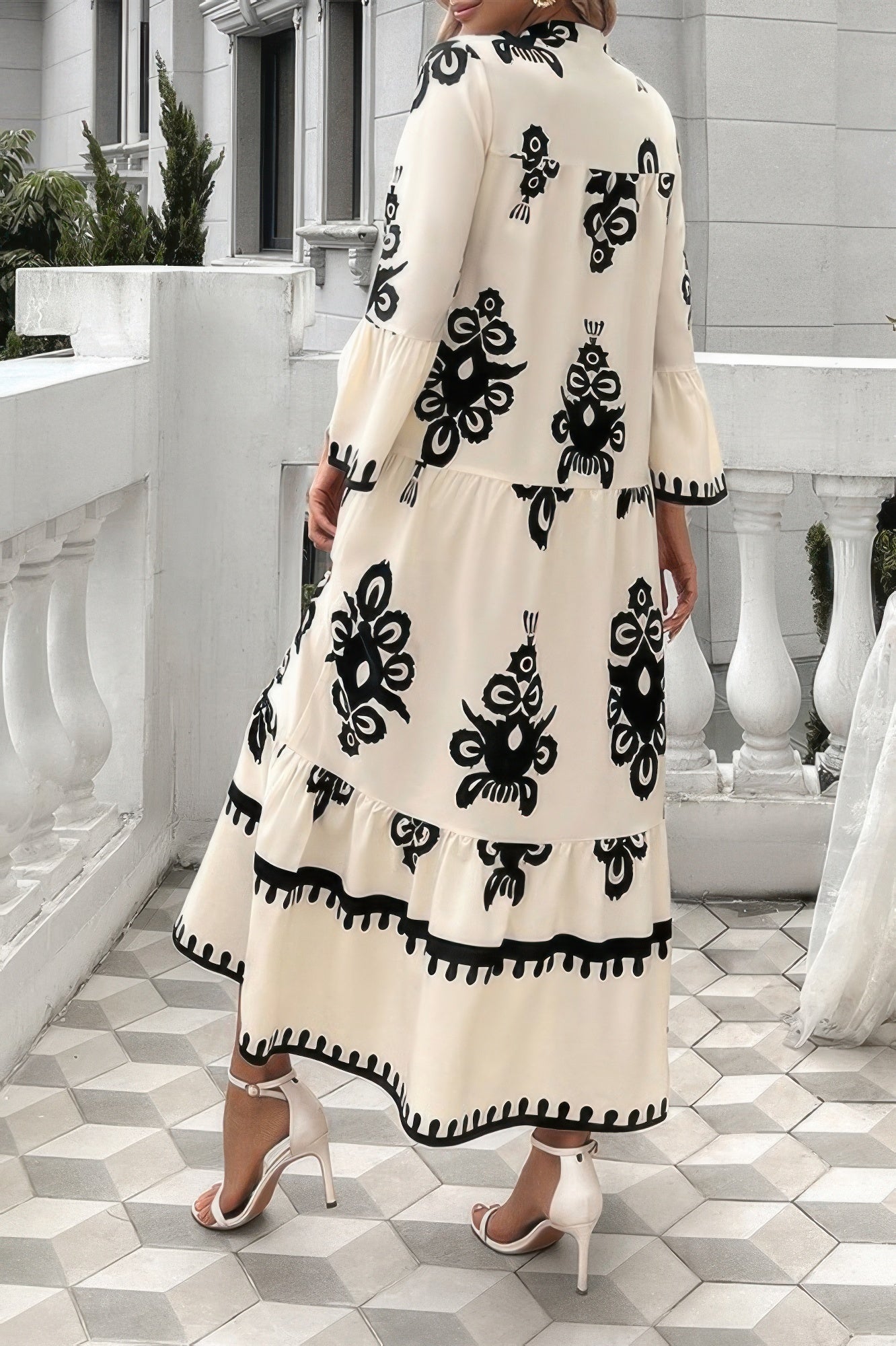 Cream button-front maxi dress with V-neck stand collar; black floral pattern and scalloped border