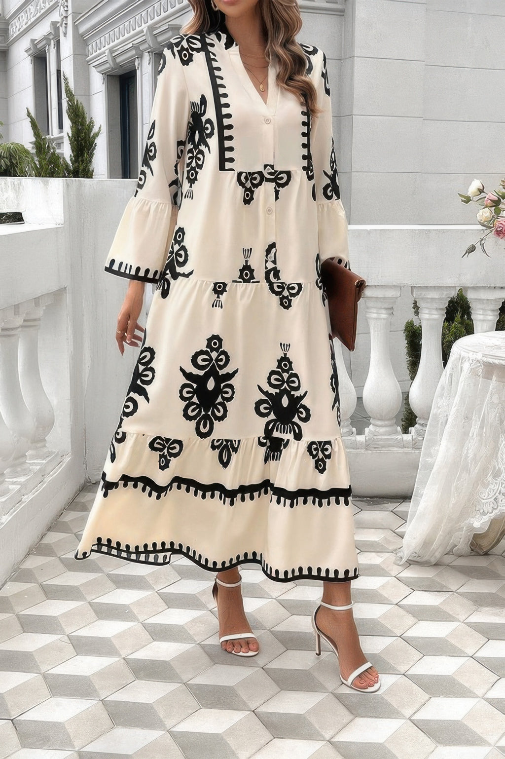 Cream dress with V-neck stand collar and button placket; black floral motifs on flared skirt
