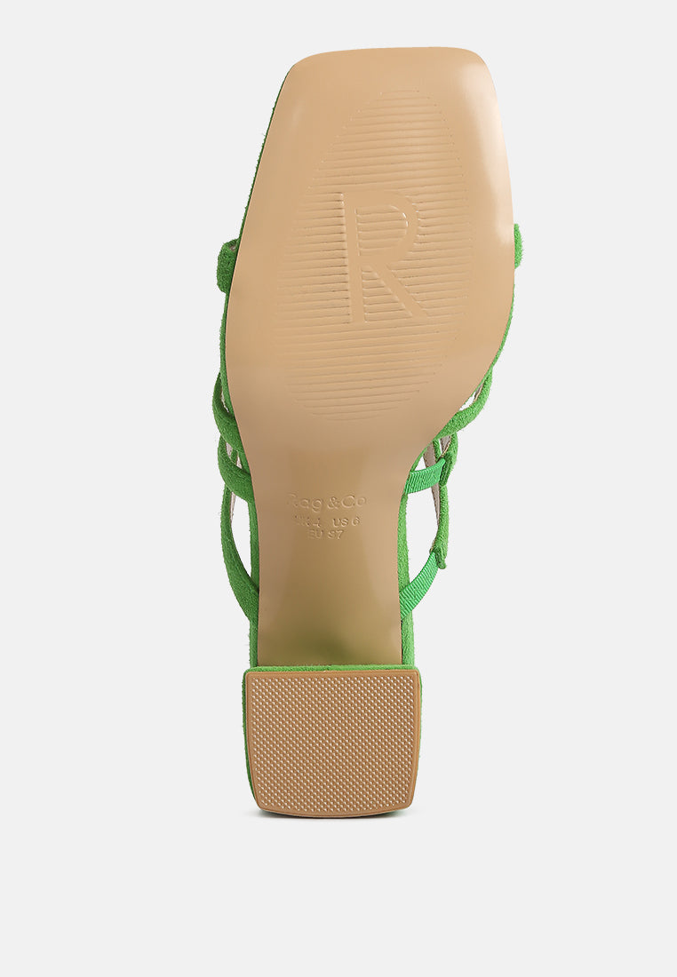 Mint green block-heel sandals showing textured outsole and crisscross straps