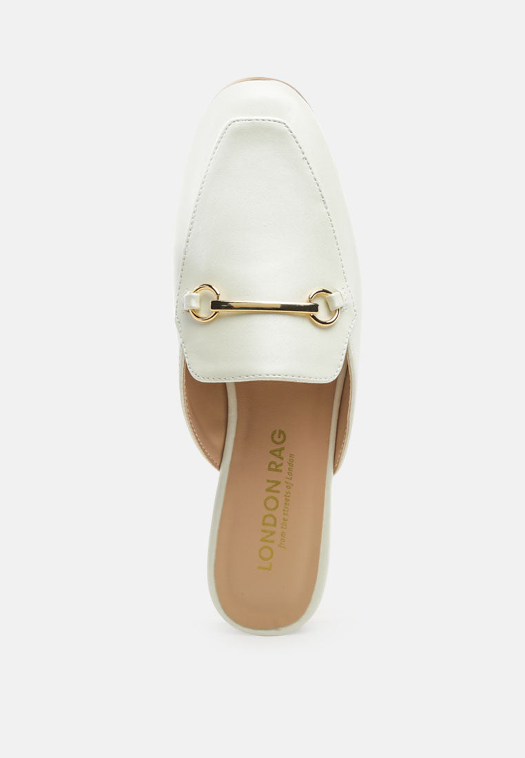White mule close-up with gold horsebit bar and stitched vamp