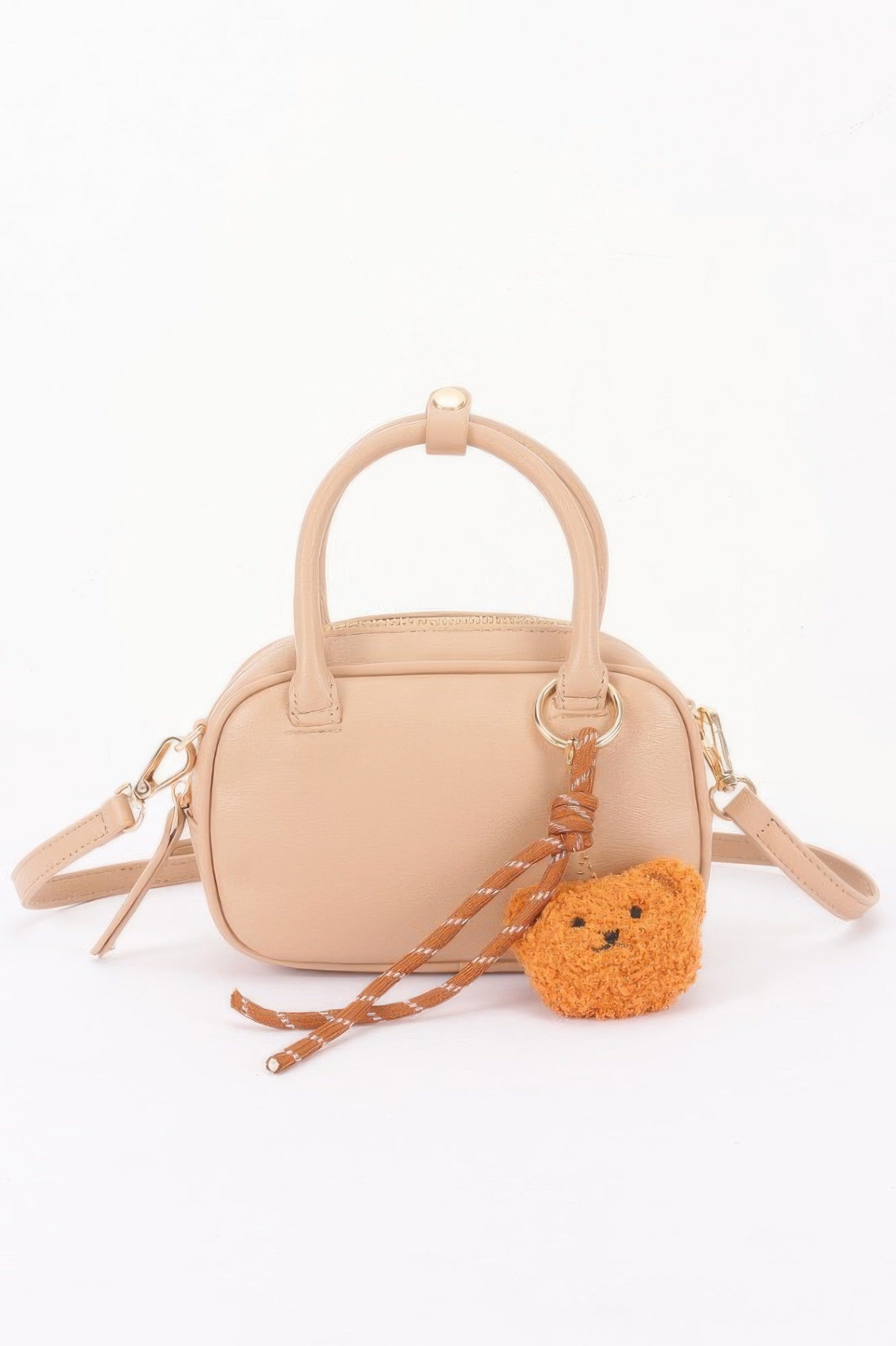 Vegan leather mini bowling bag in nude with bear charm and adjustable crossbody strap