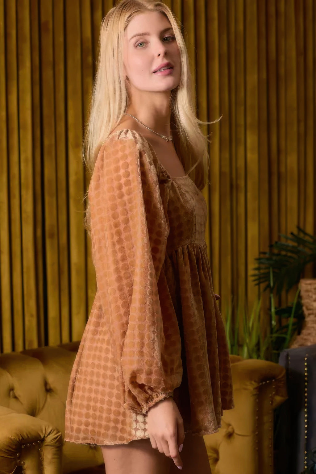 Side view of brown long-sleeve square-neck romper with loose tiered silhouette