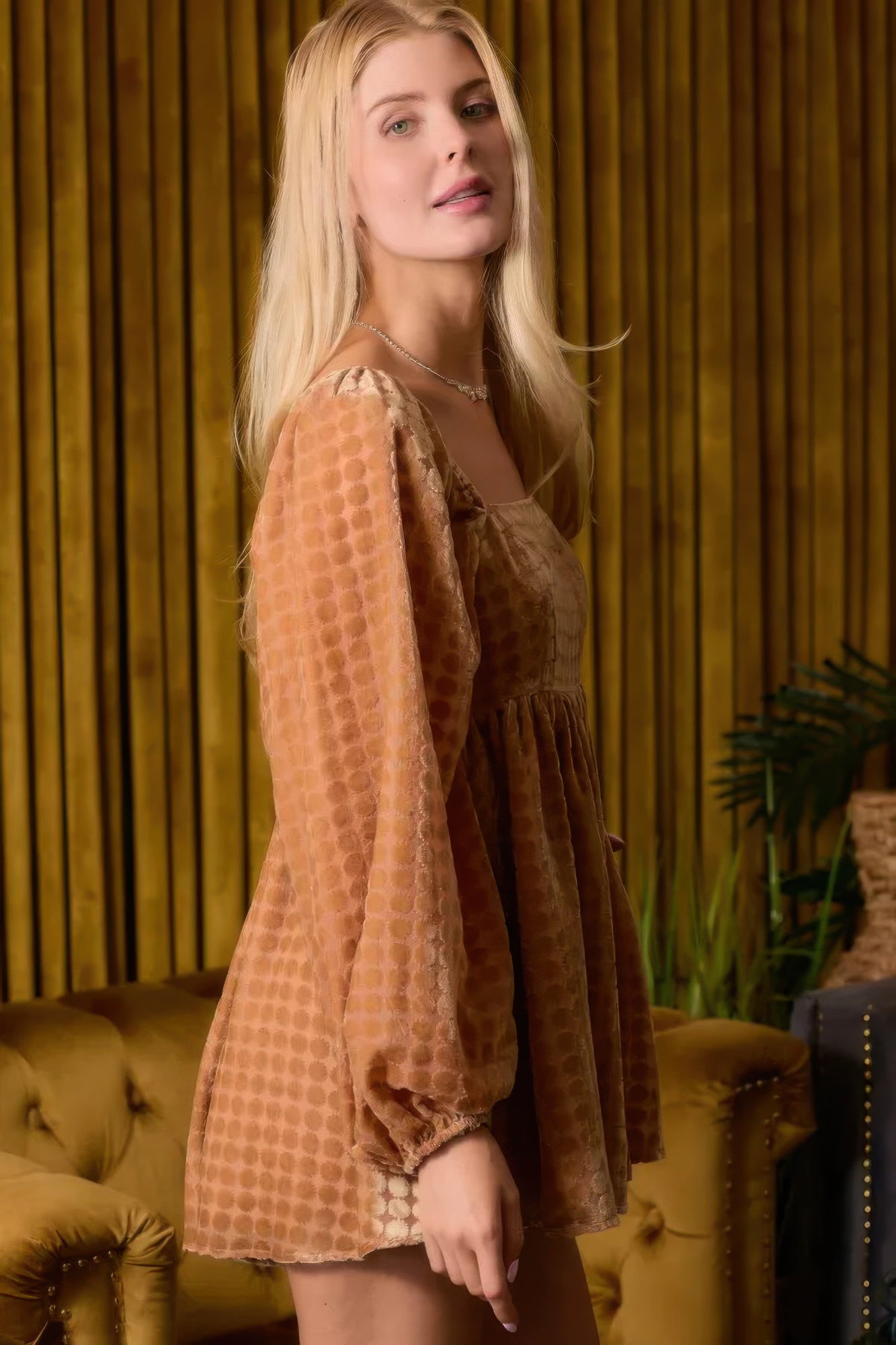 Side view of brown long-sleeve square-neck romper with loose tiered silhouette