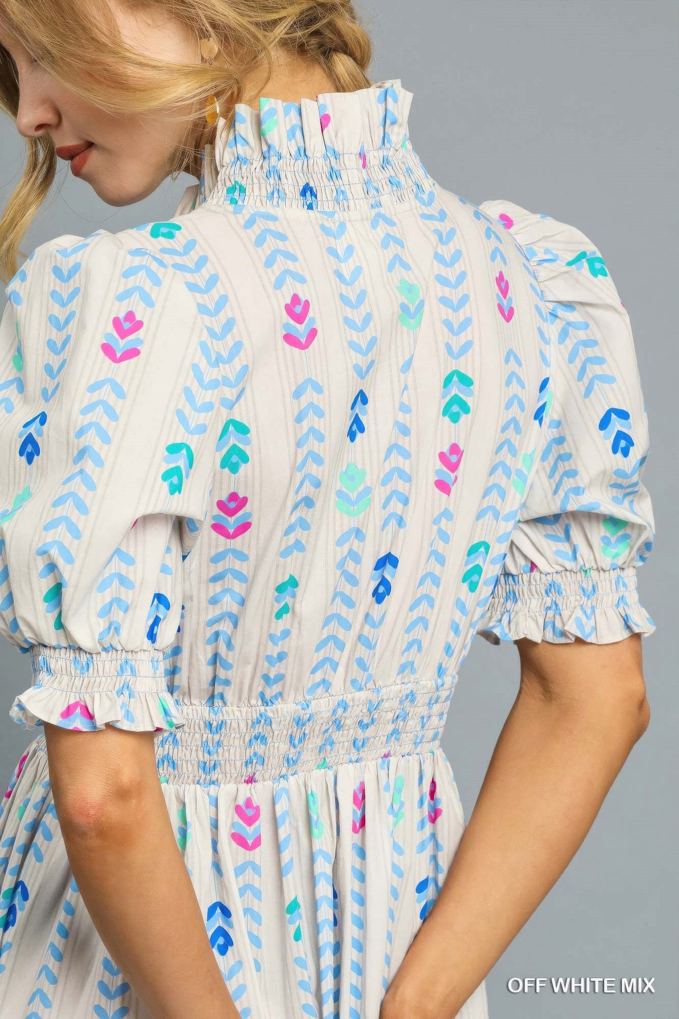 Close-up: off-white smocked yoke midi dress with puff sleeves and multicolor print