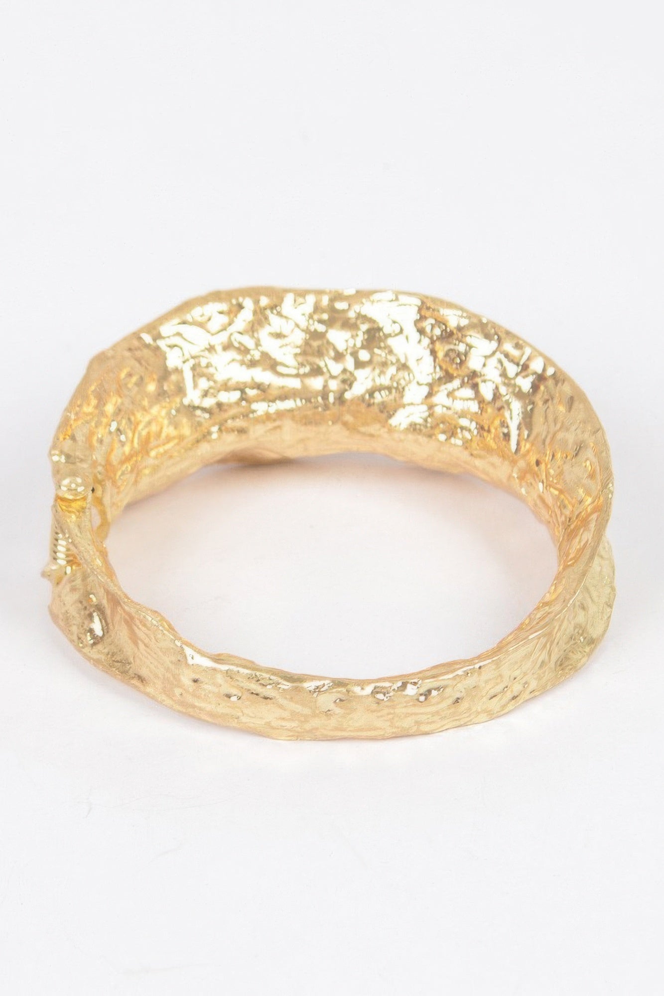 Gold metal cuff bracelet close view, smooth inner opening and textured outer band