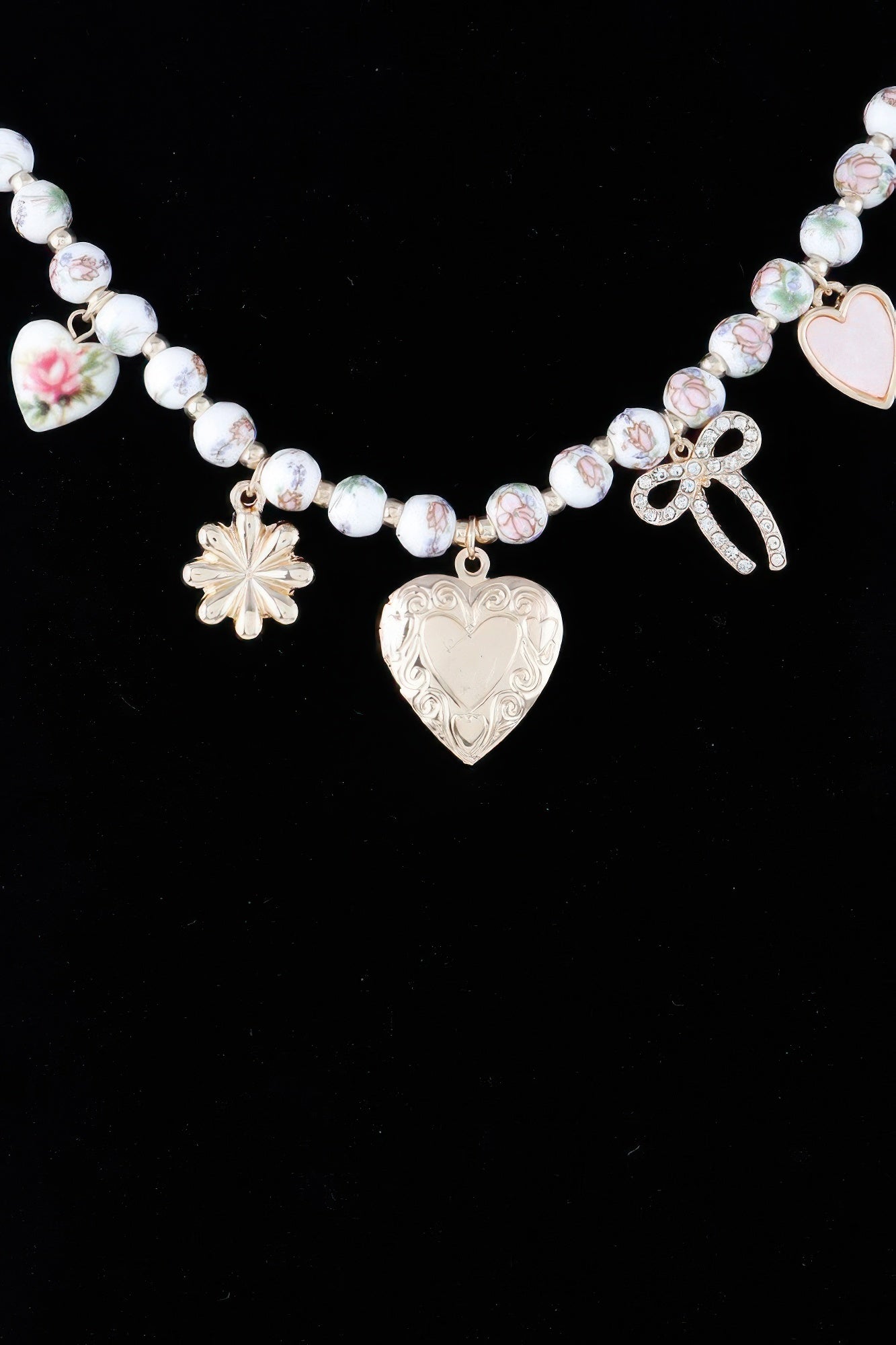 Heart charms necklace with large heart pendant, bow charm, and flower dangle on pink beads