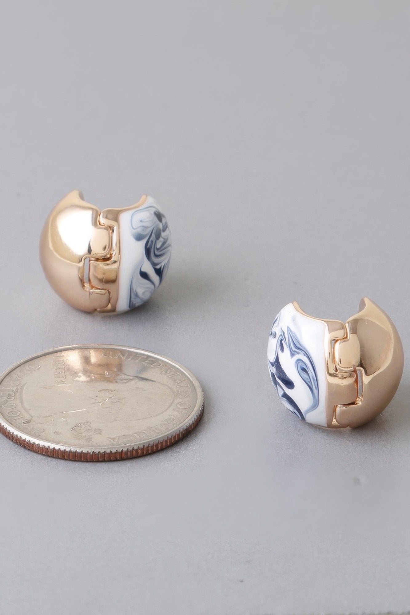Small gold-tone clasp earrings with blue marble swirl inlaid discs