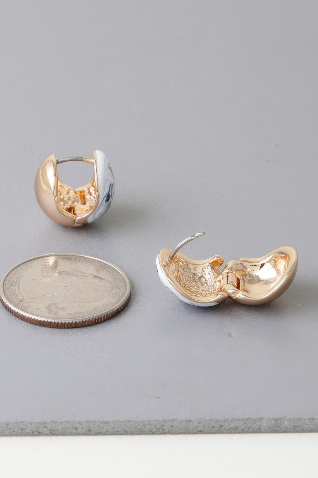 Open-back view of gold-tone clasp earrings with blue marble swirl inlay