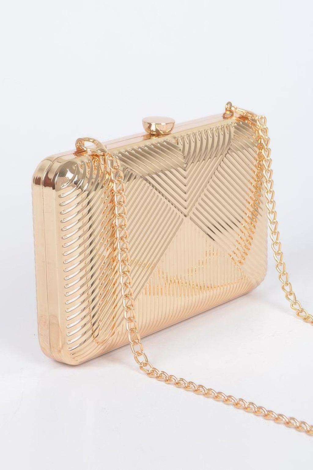 Gold metal clutch with rounded clasp and chevron ribbed texture, side view