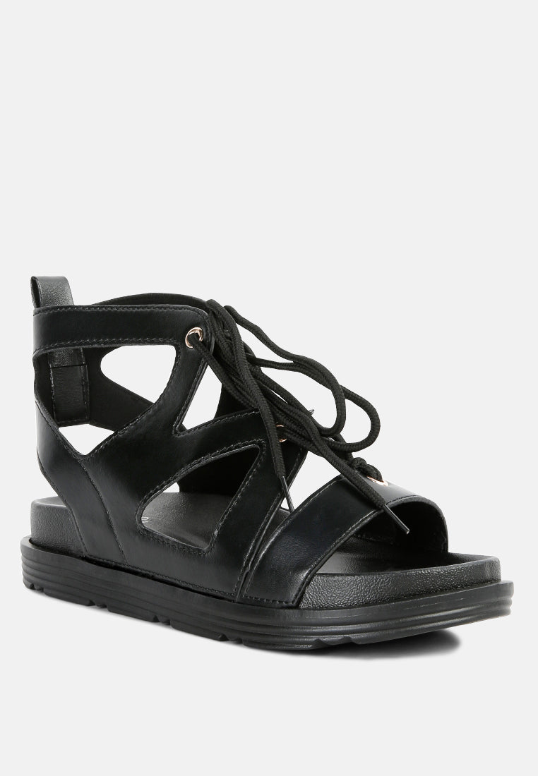 Black open-toe flat sandals with crisscross laces and textured outsole