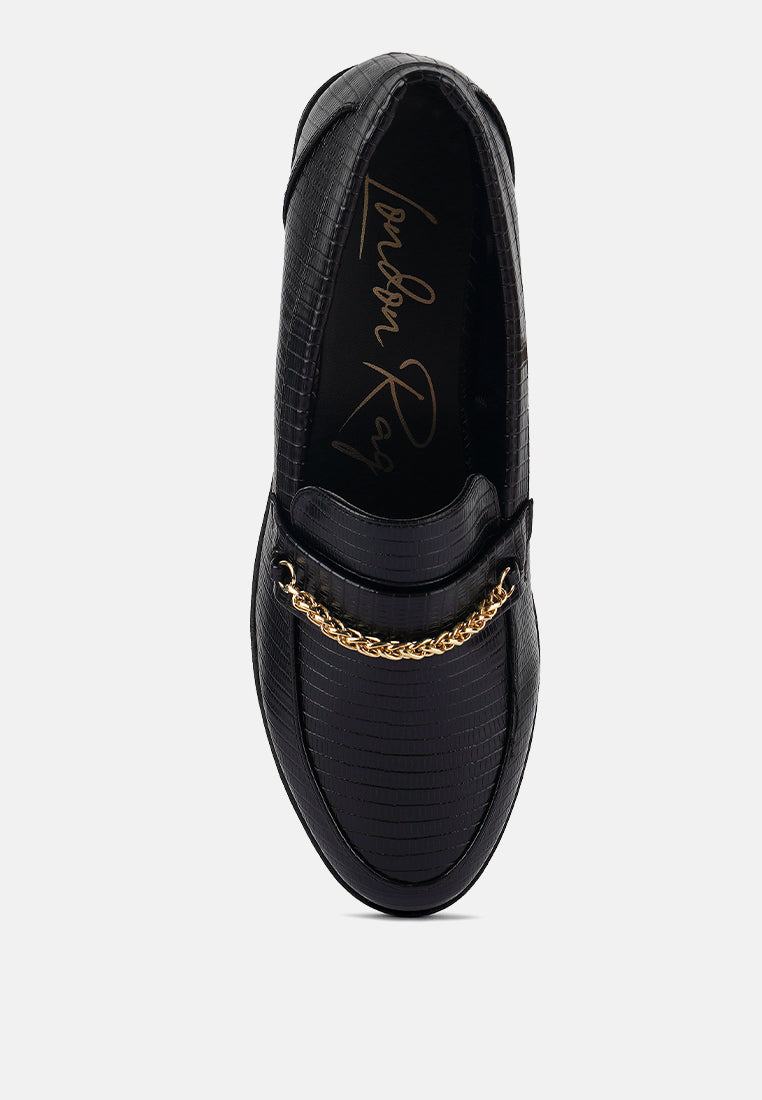 Black loafers with gold chain detail across the vamp, closed almond toe
