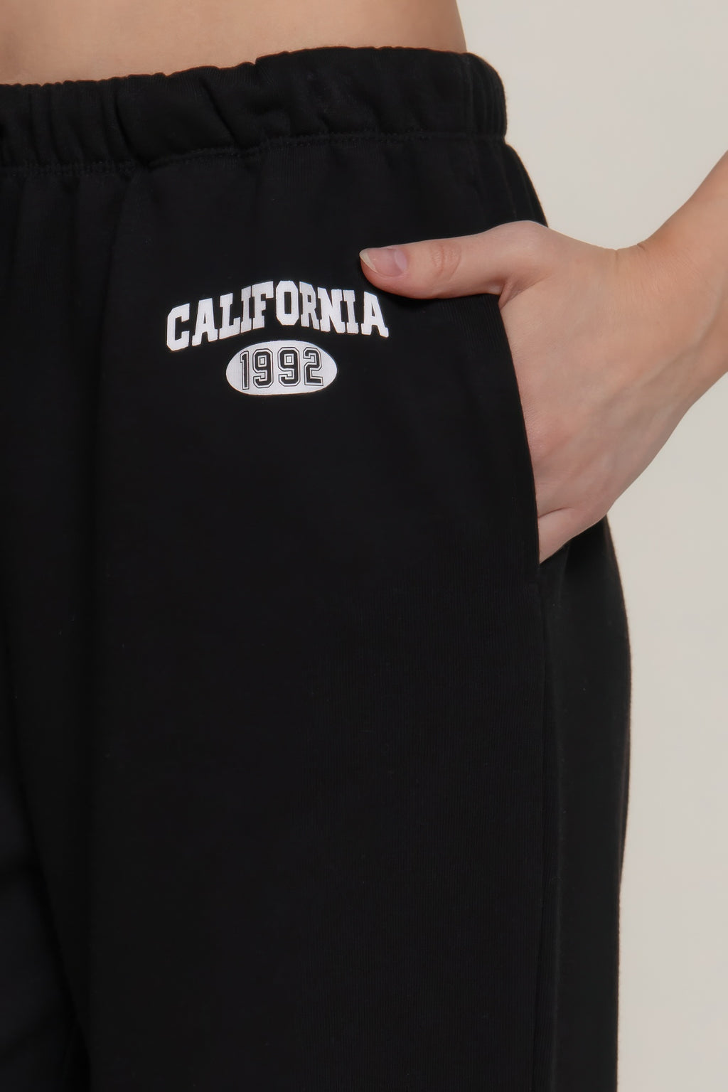 Black sweatpants waistband close-up with 'California 1992' print