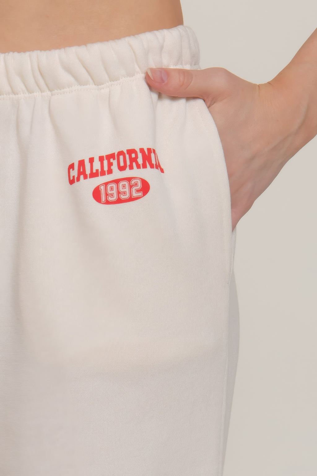 Buttercream sweatpants waistband close-up with 'California 1992' red print