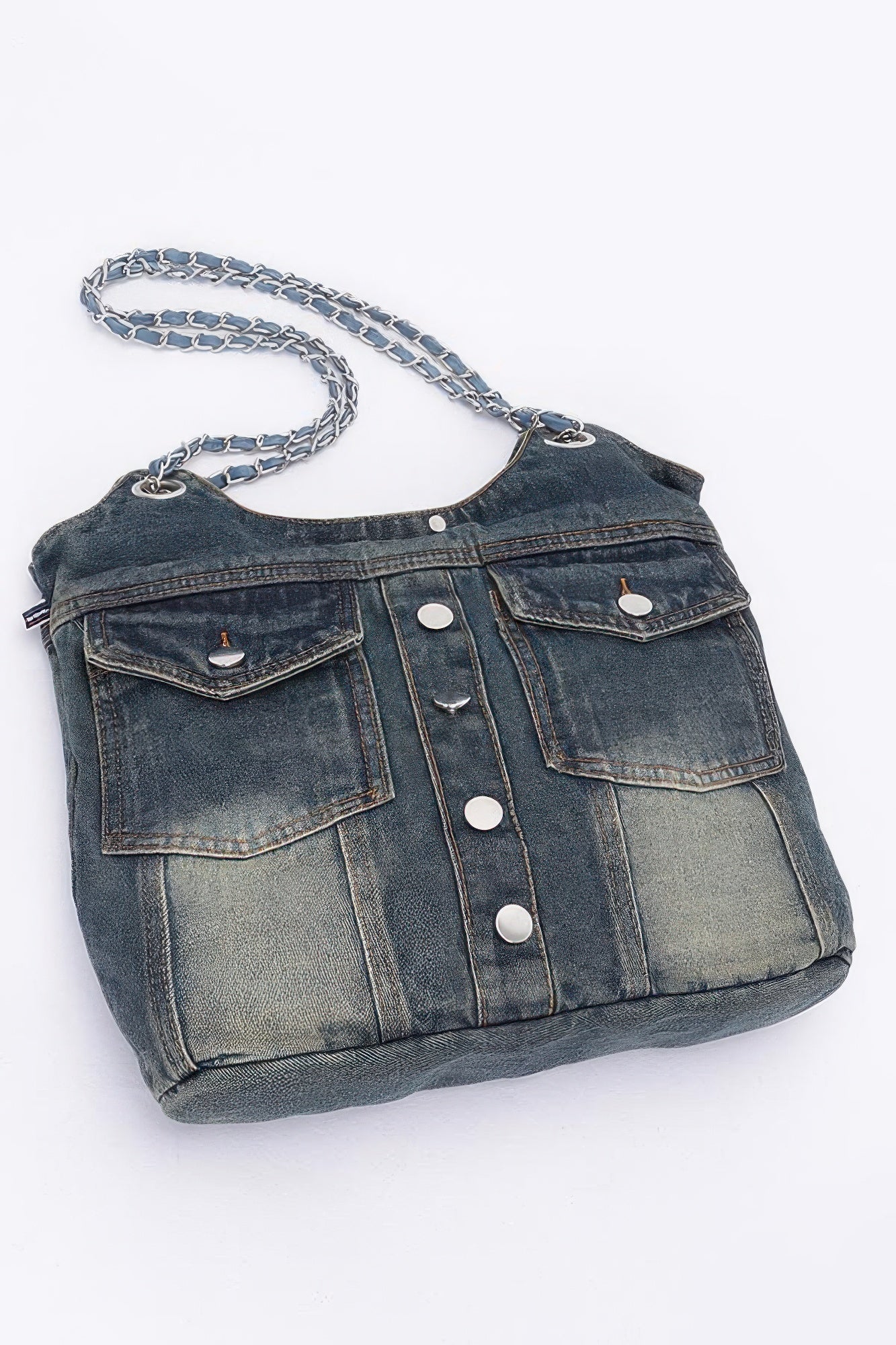 Washed denim tote with two front flap pockets and silver snap buttons, chain strap