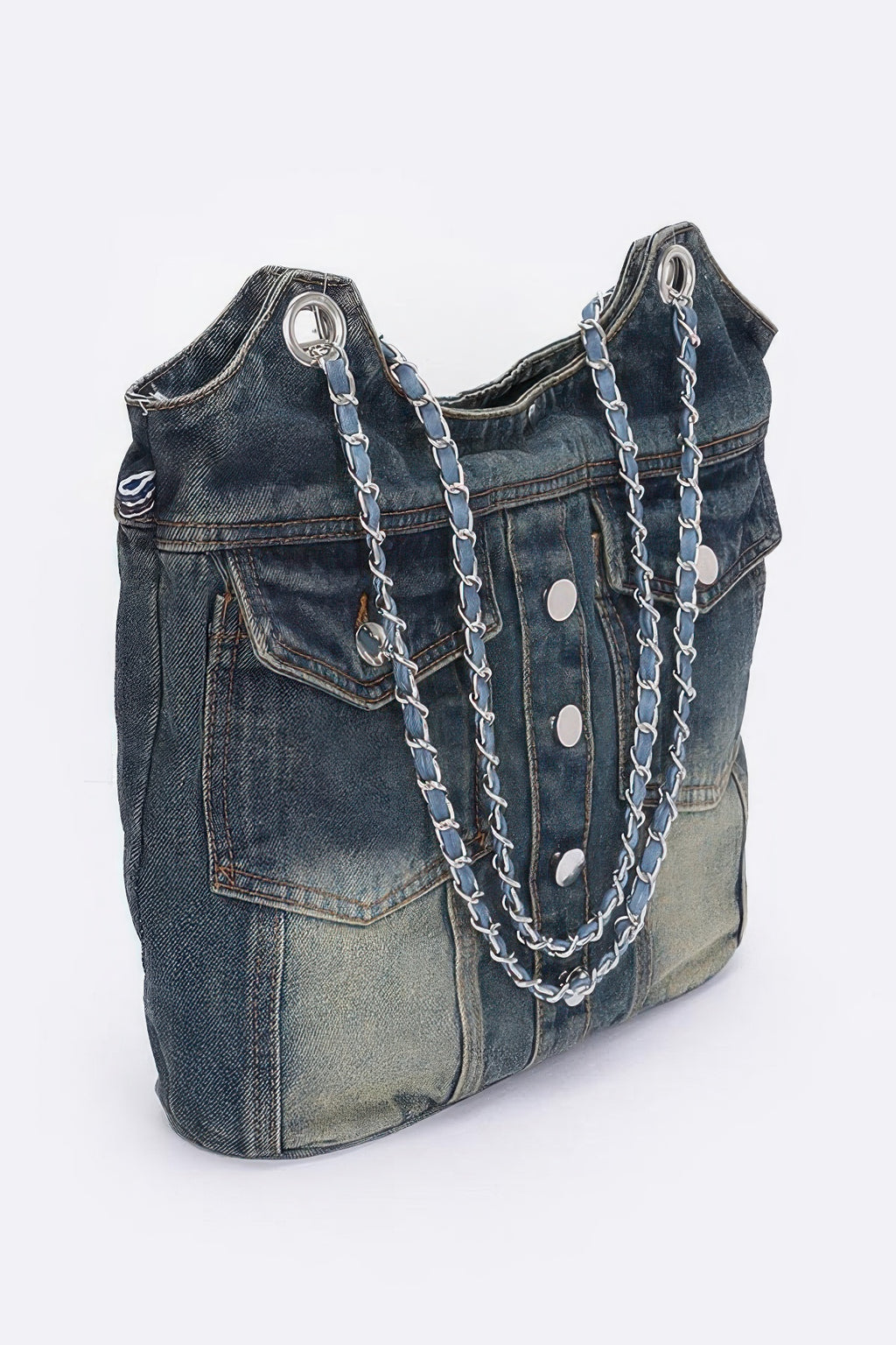 Washed denim tote bag with front flap pockets, oval metal rings, and chain handles