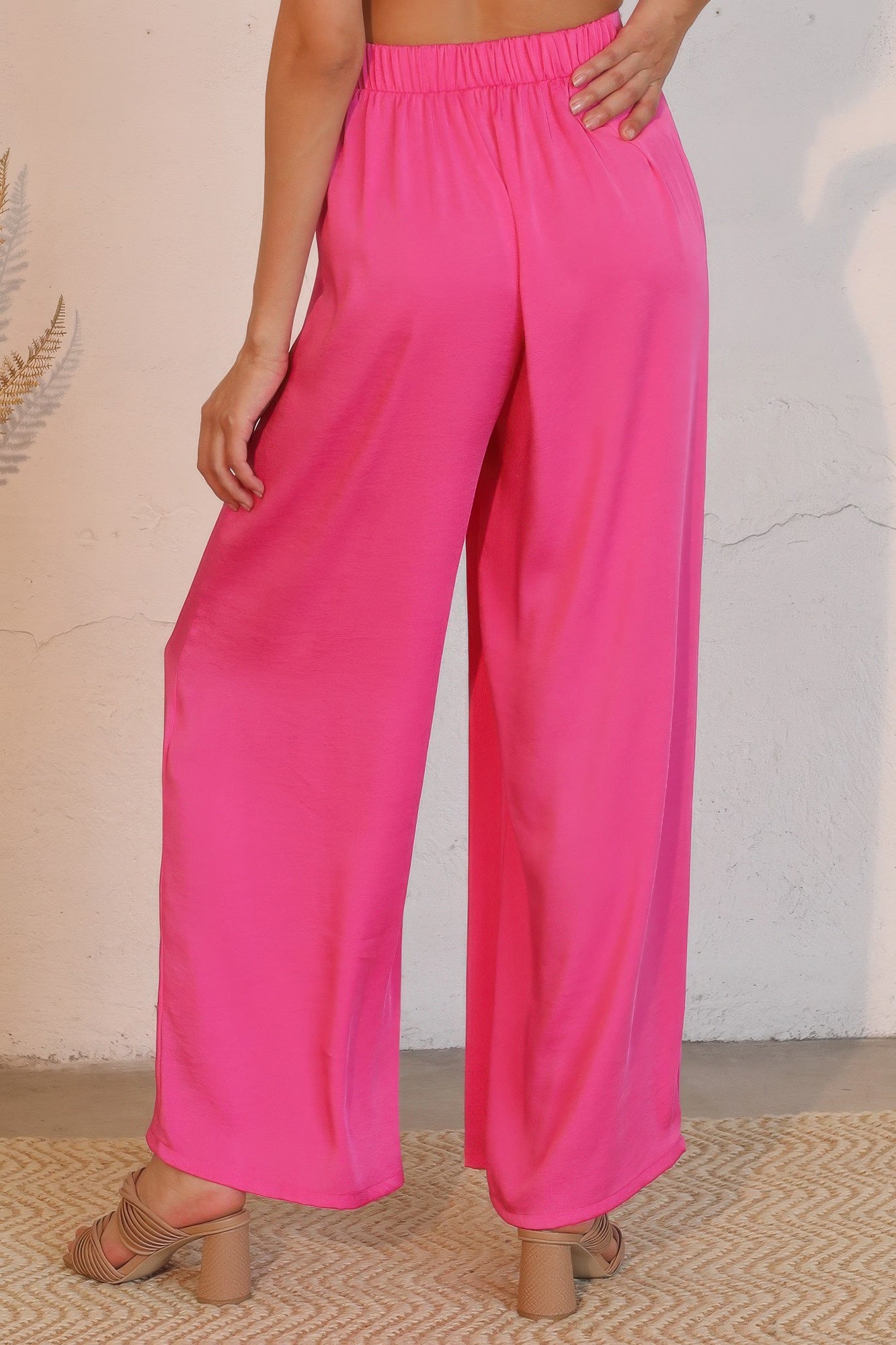 Pinkfarbene weite Hose mit elastischem Bund, fließendem Stoff und Asymmetriefalten vorn