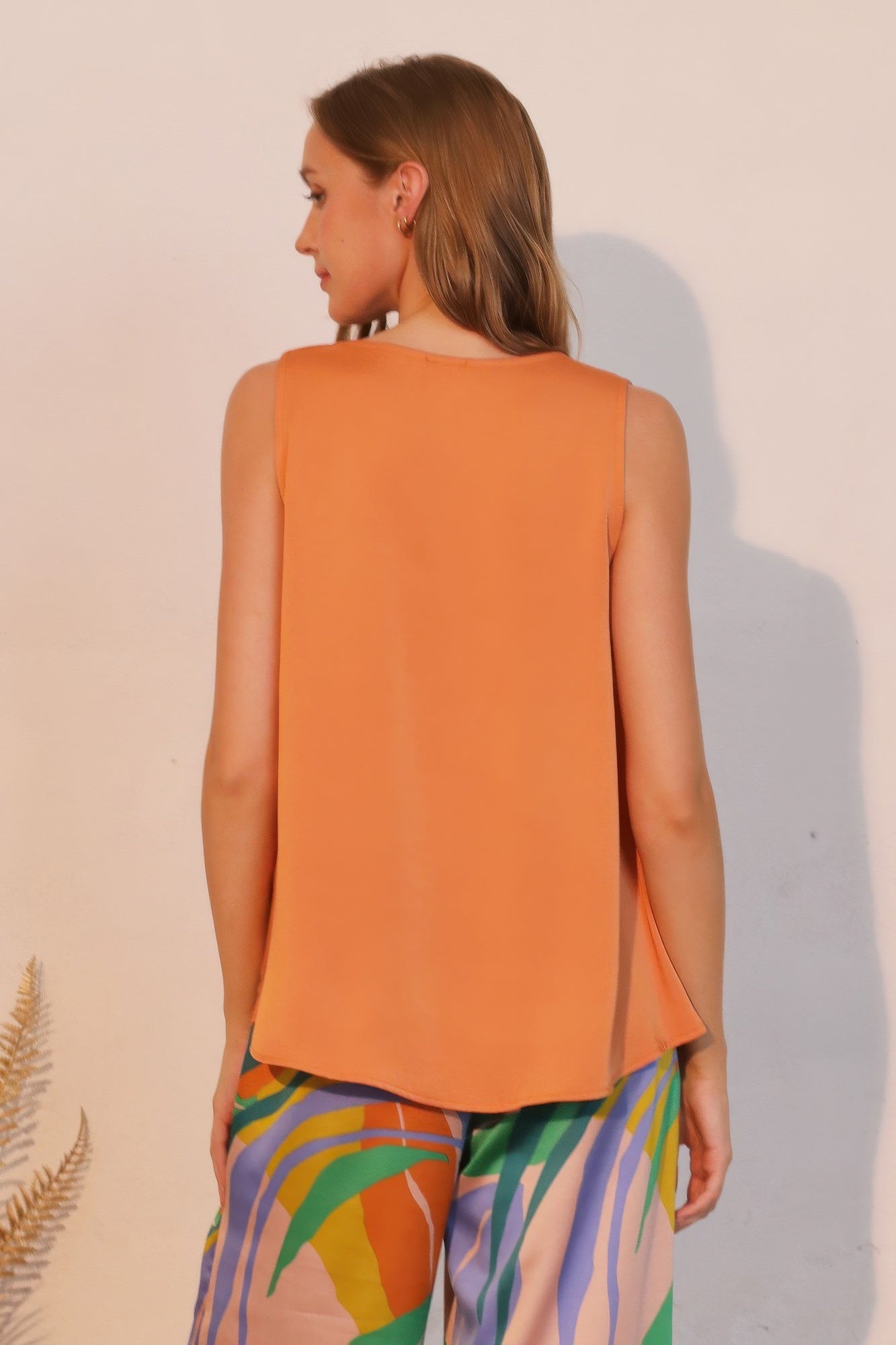 Washed poly silk front tucked top, pumpkin back view with flowing drape