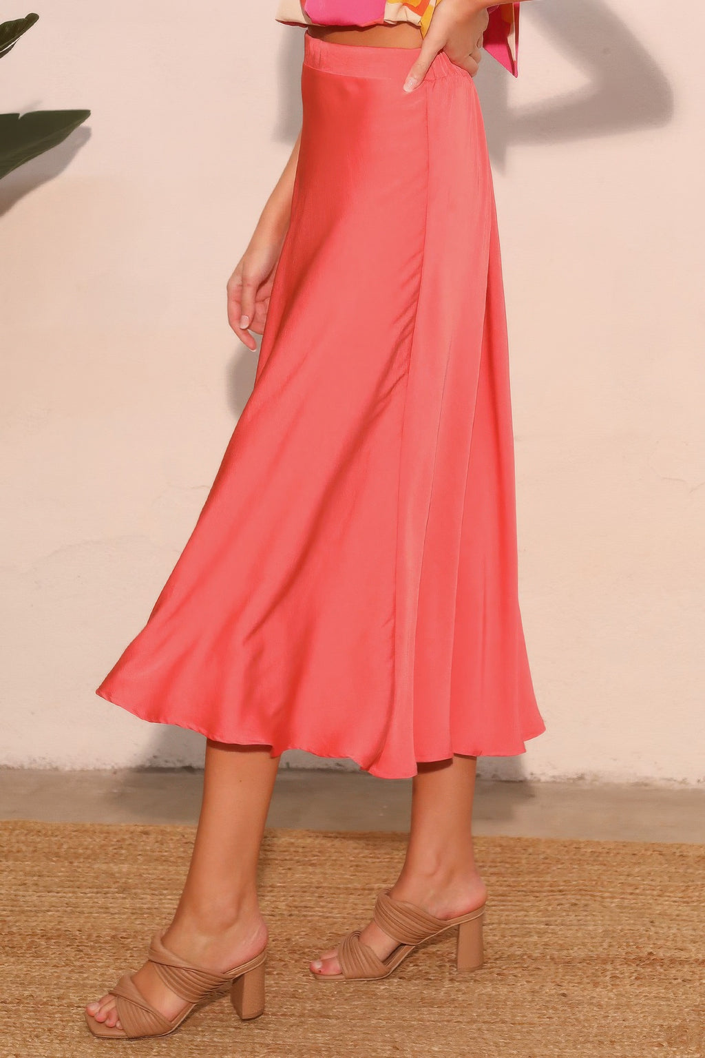 Coral pink midi swing skirt with smooth drape and elastic waist, flowing A-line shape