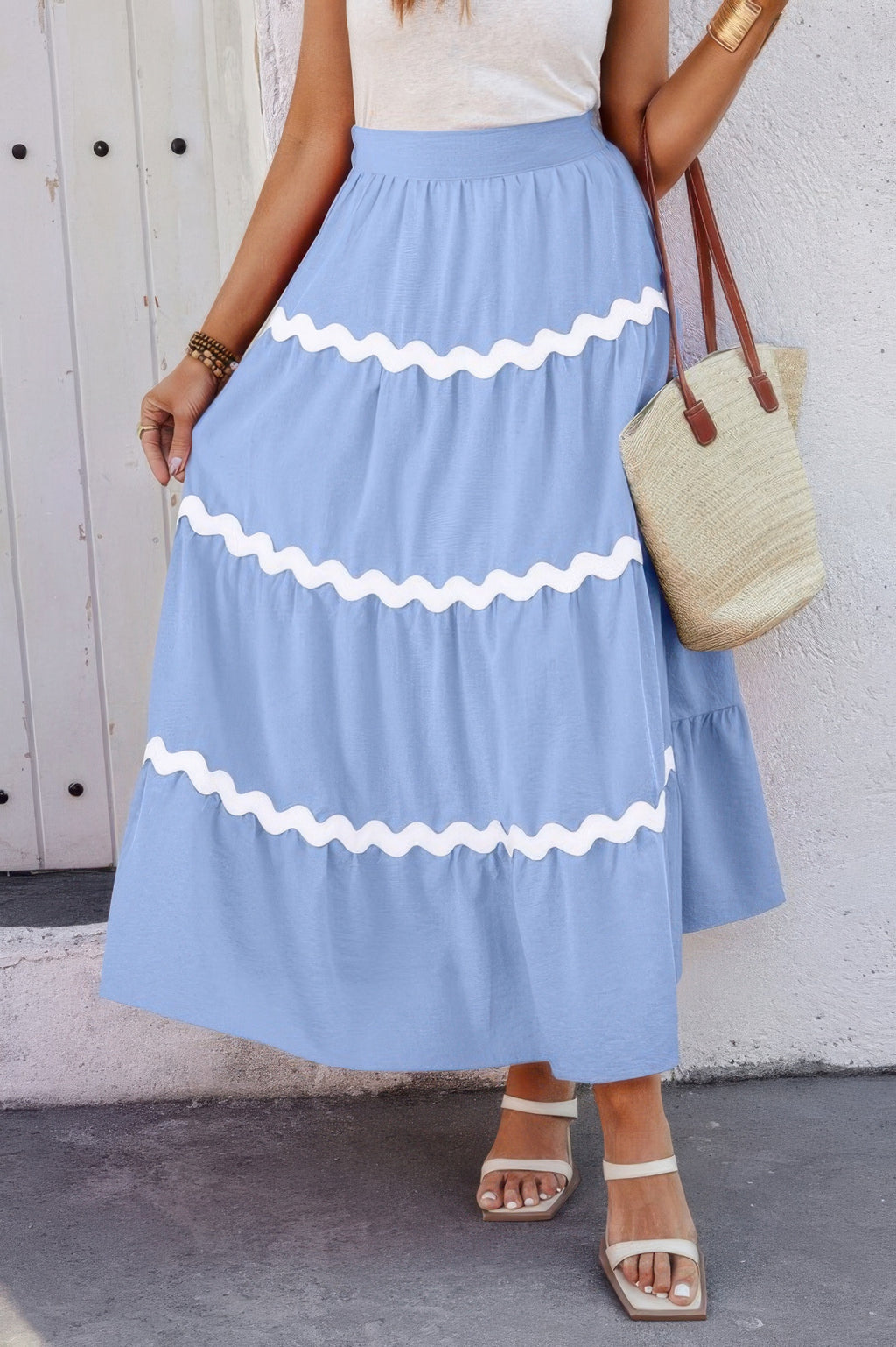 Blue pleated skirt with elastic waistband and white zigzag waves across tiers