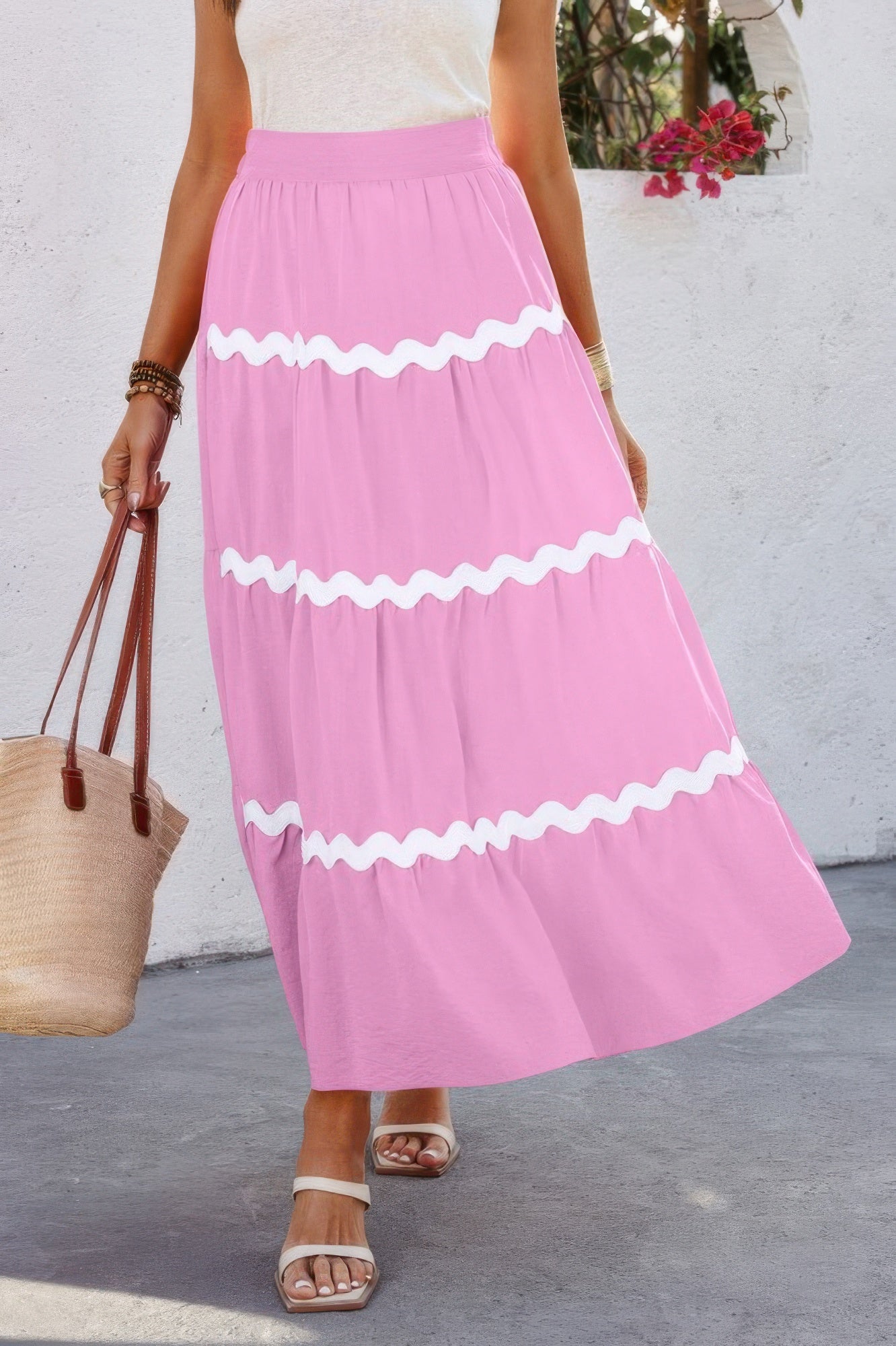 Pink pleated skirt with elastic waistband and white zigzag waves across tiers