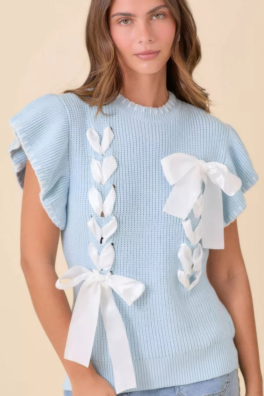 Light blue knit sweater top with white ribbon bows on front panels