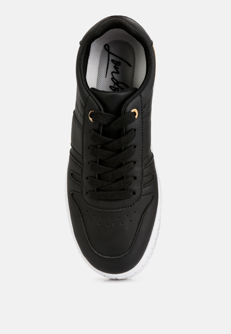 Black sneakers with interior branding and lace-up front, gold lace tips