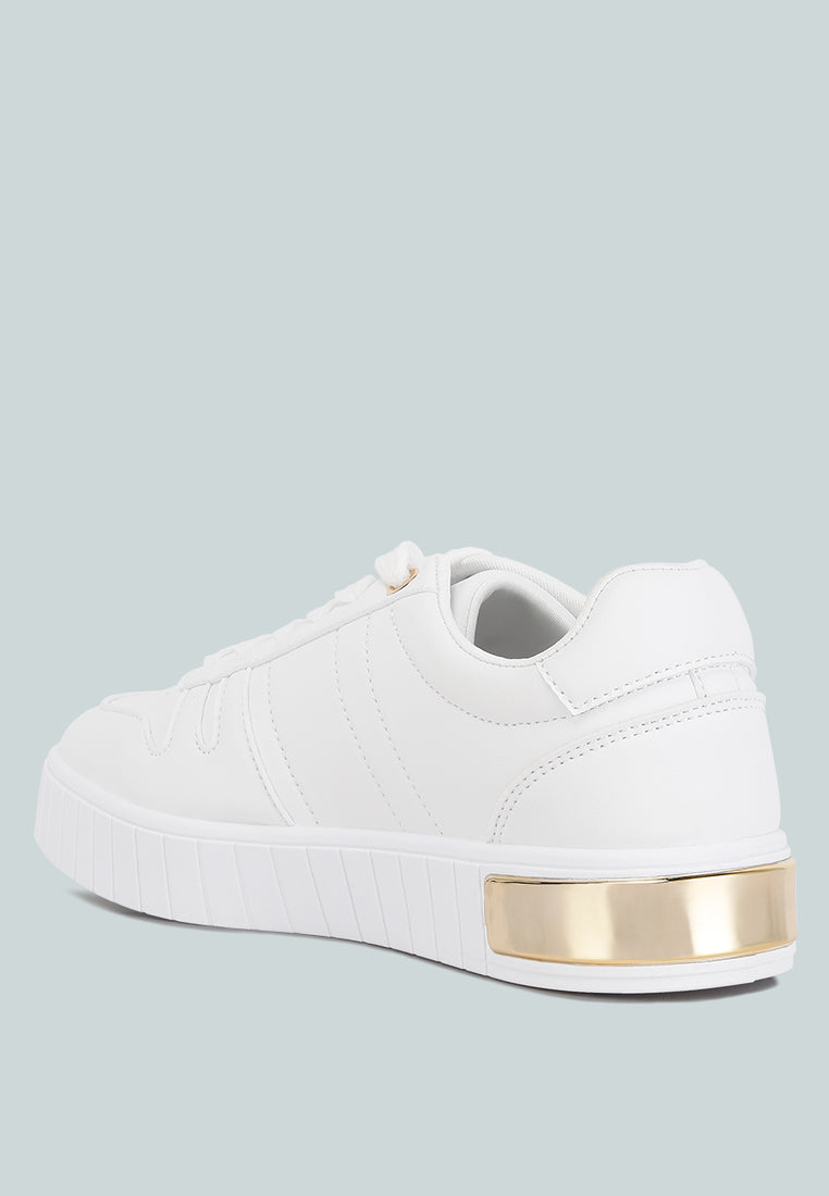 White low-top sneakers with gold heel trim and textured sole edge