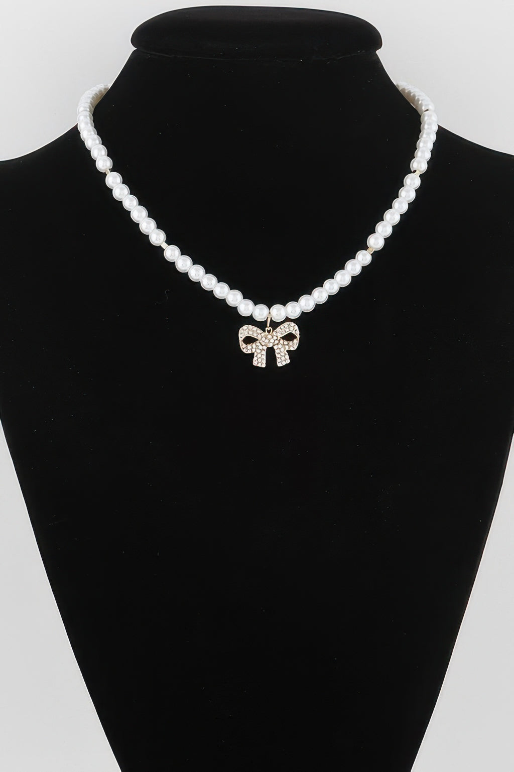 White pearl bow necklace with rhinestone bow pendant on bead strand