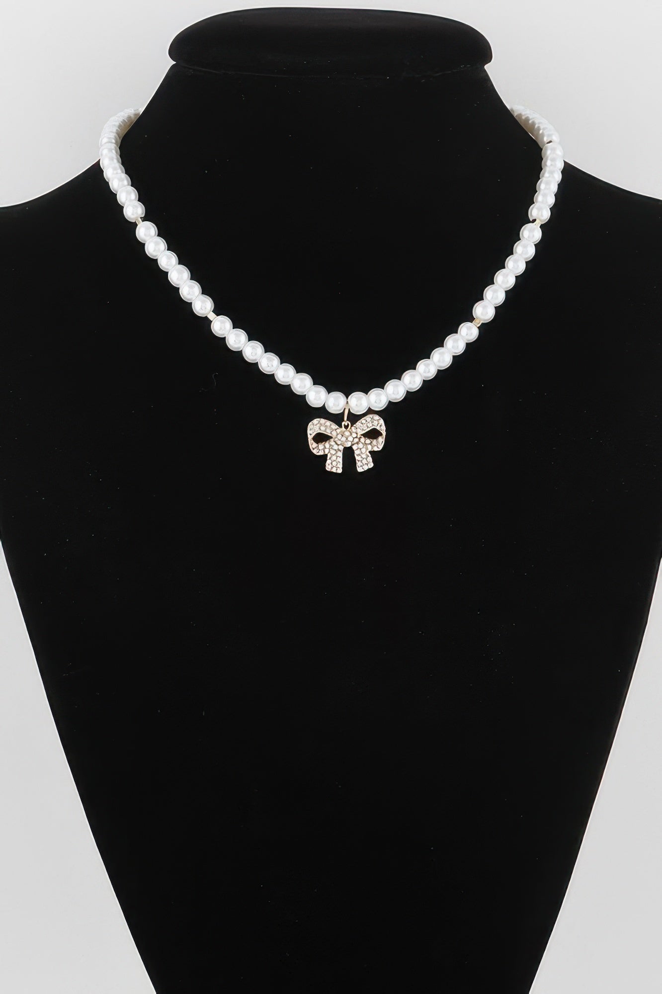 White pearl bow necklace with rhinestone bow pendant on bead strand