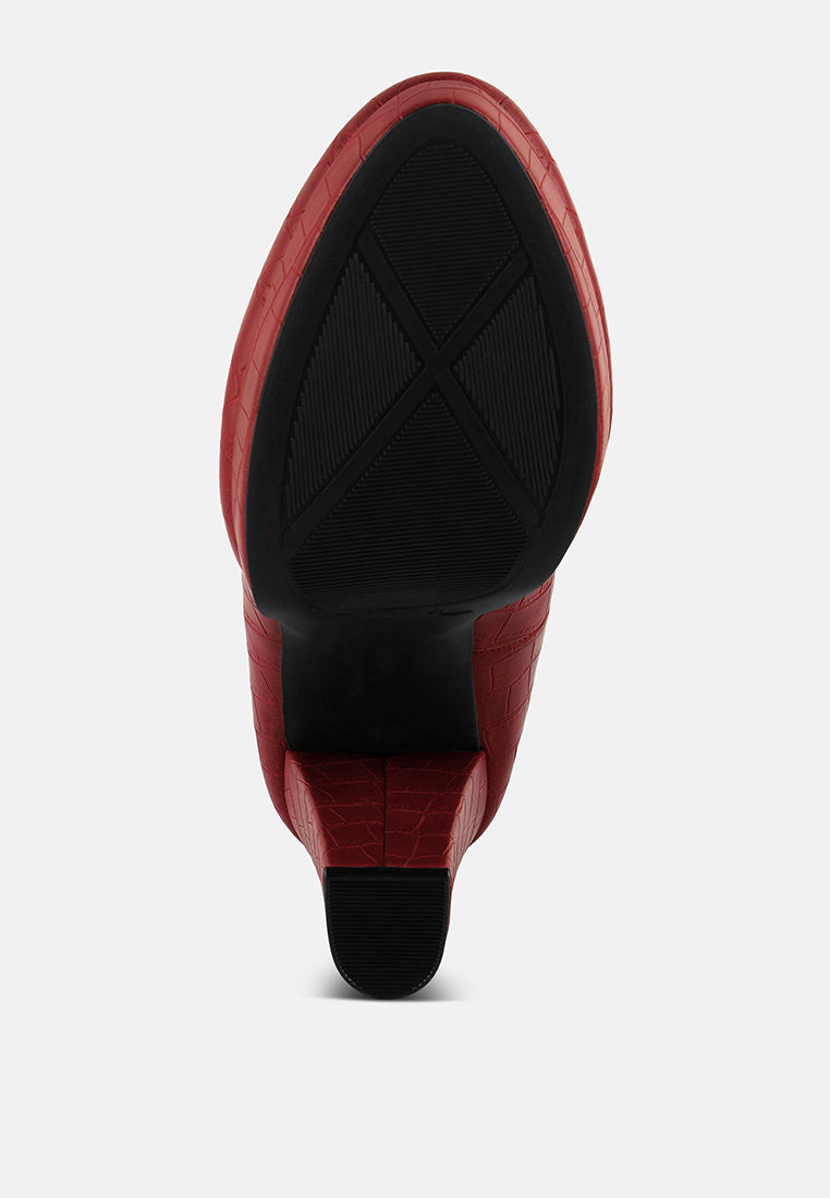 Back view of red croc-texture high block heel pumps with textured outsole.