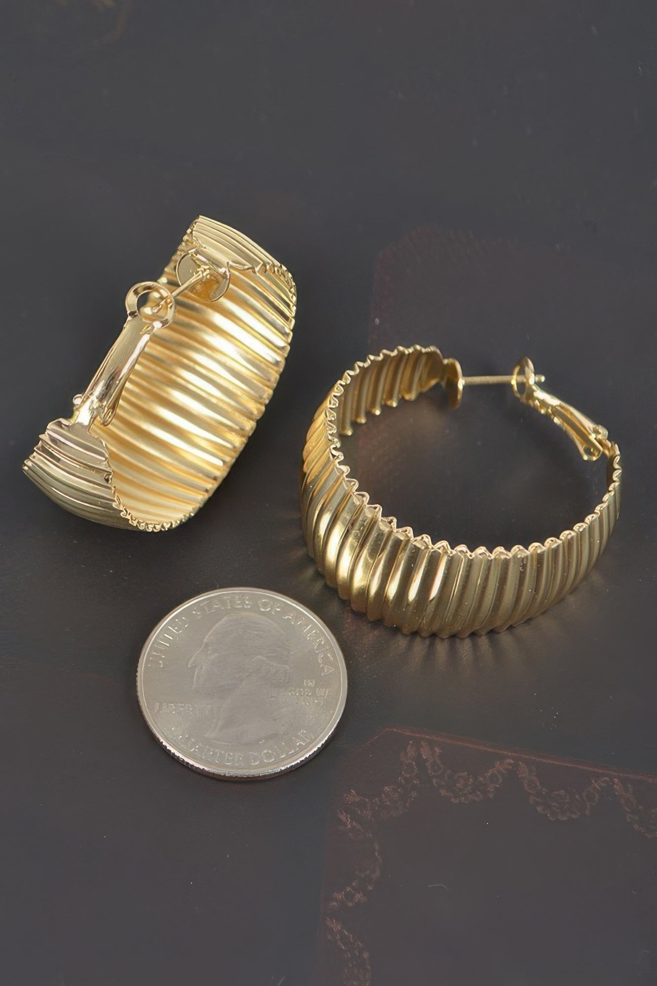 Wide gold ribbed hoop earrings with round stud post