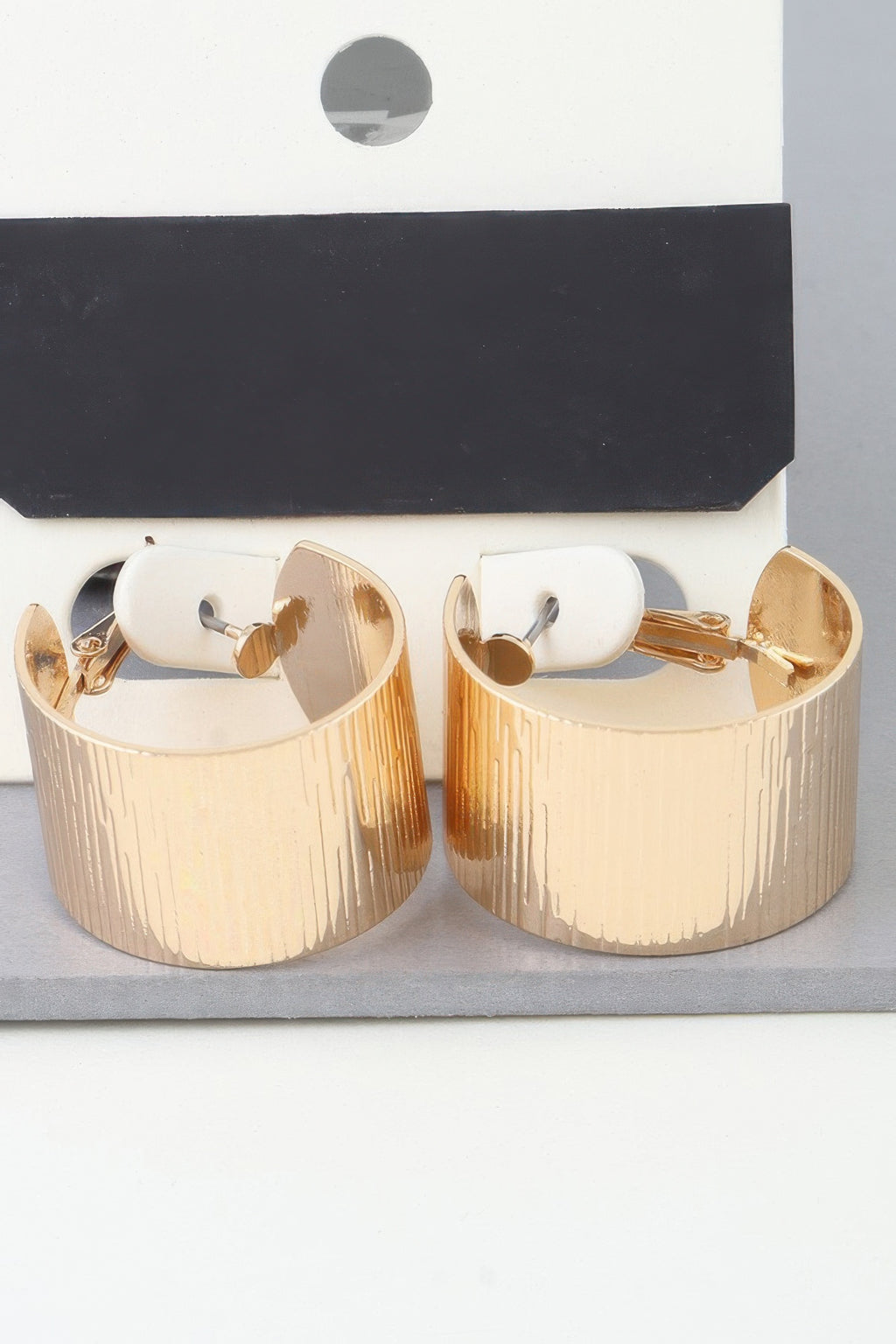 Wide ribbed gold hoop earrings, textured vertical ridges, hinged openings