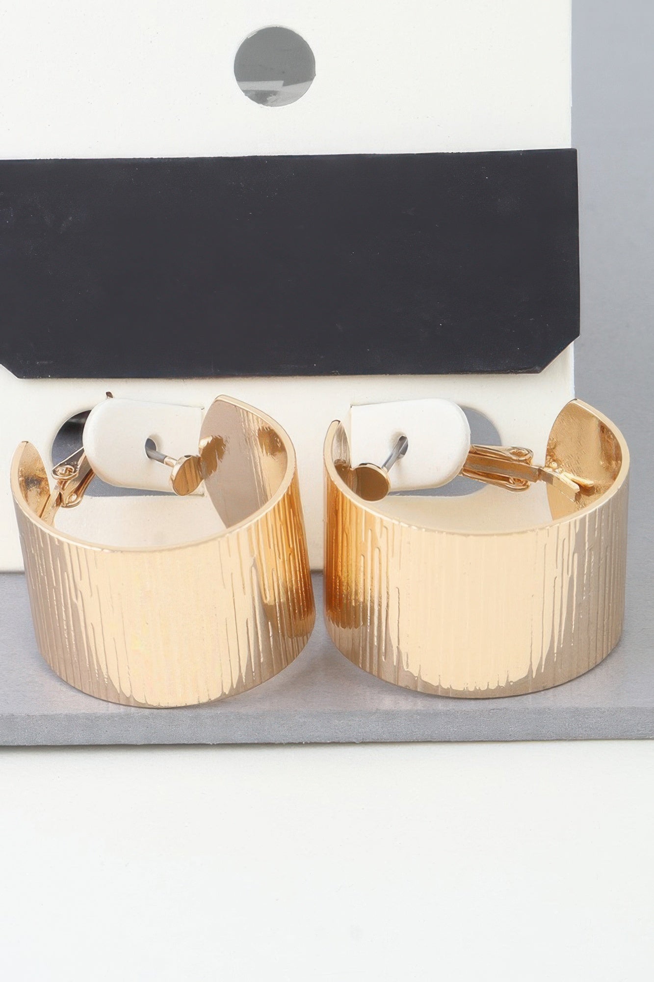 Wide ribbed gold hoop earrings, textured vertical ridges, hinged openings