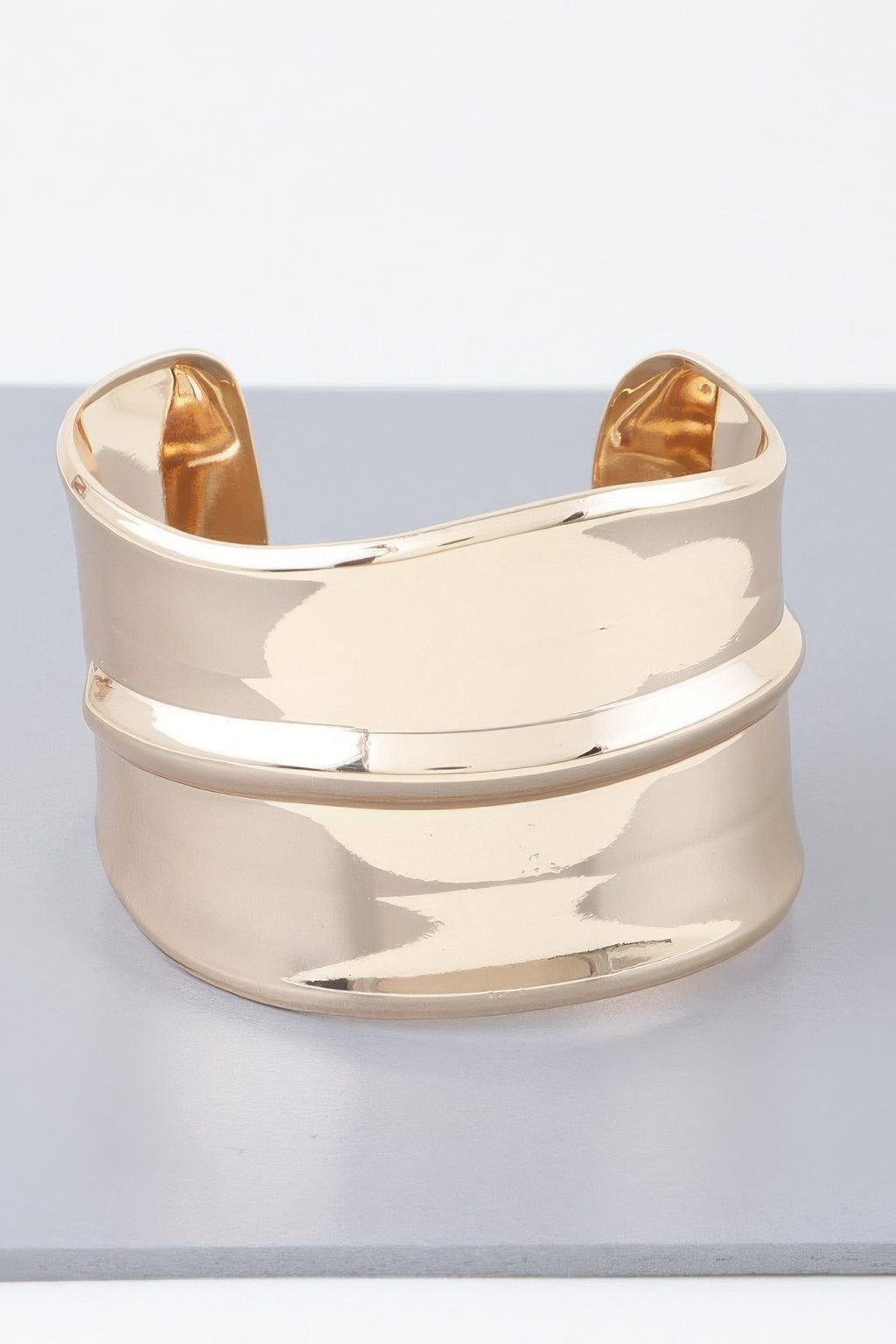 Wide shiny open cuff bracelet in gold with ribbed bar design