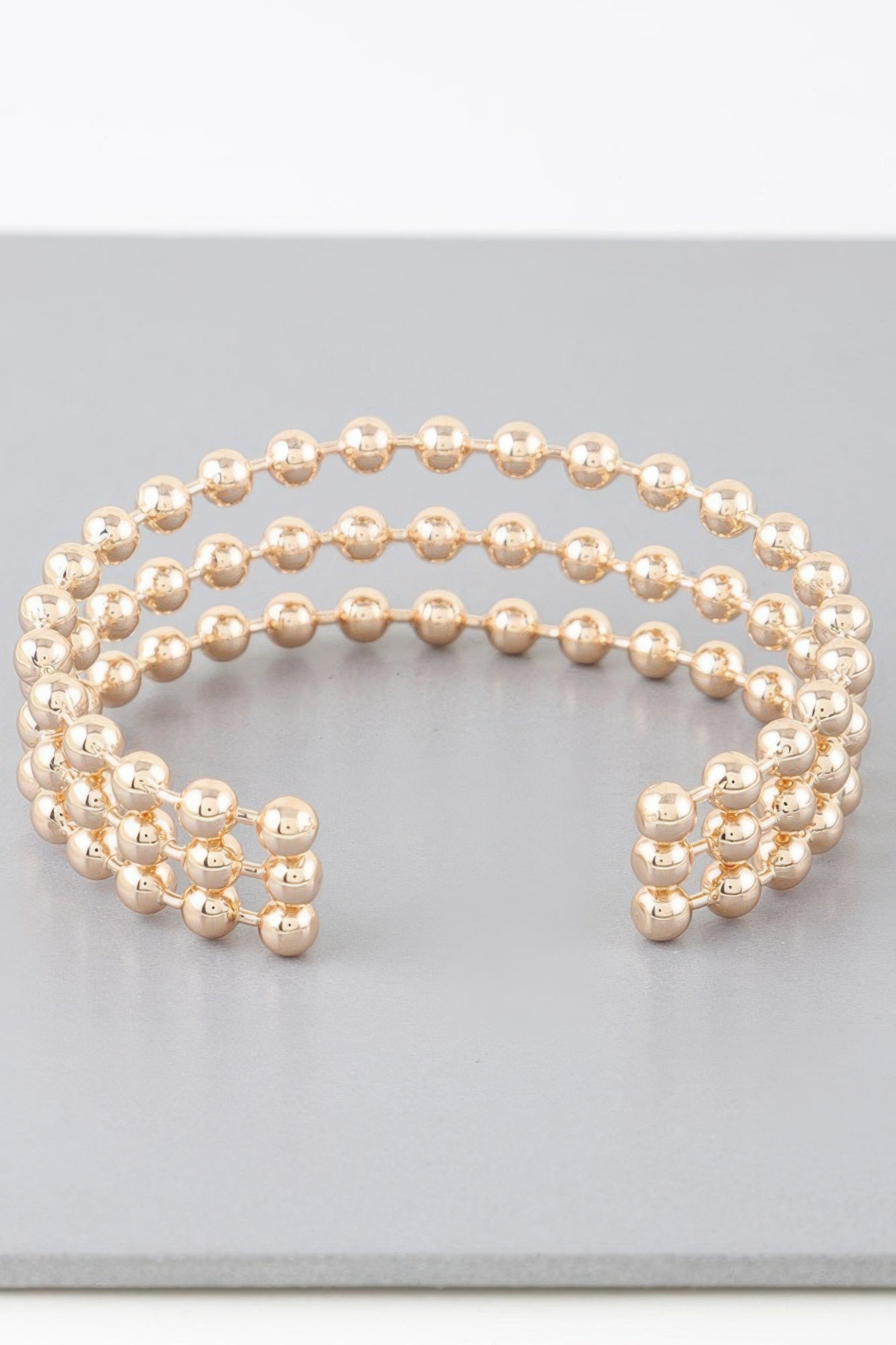 Gold triple beaded cuff bracelet, two end clusters with curved central row